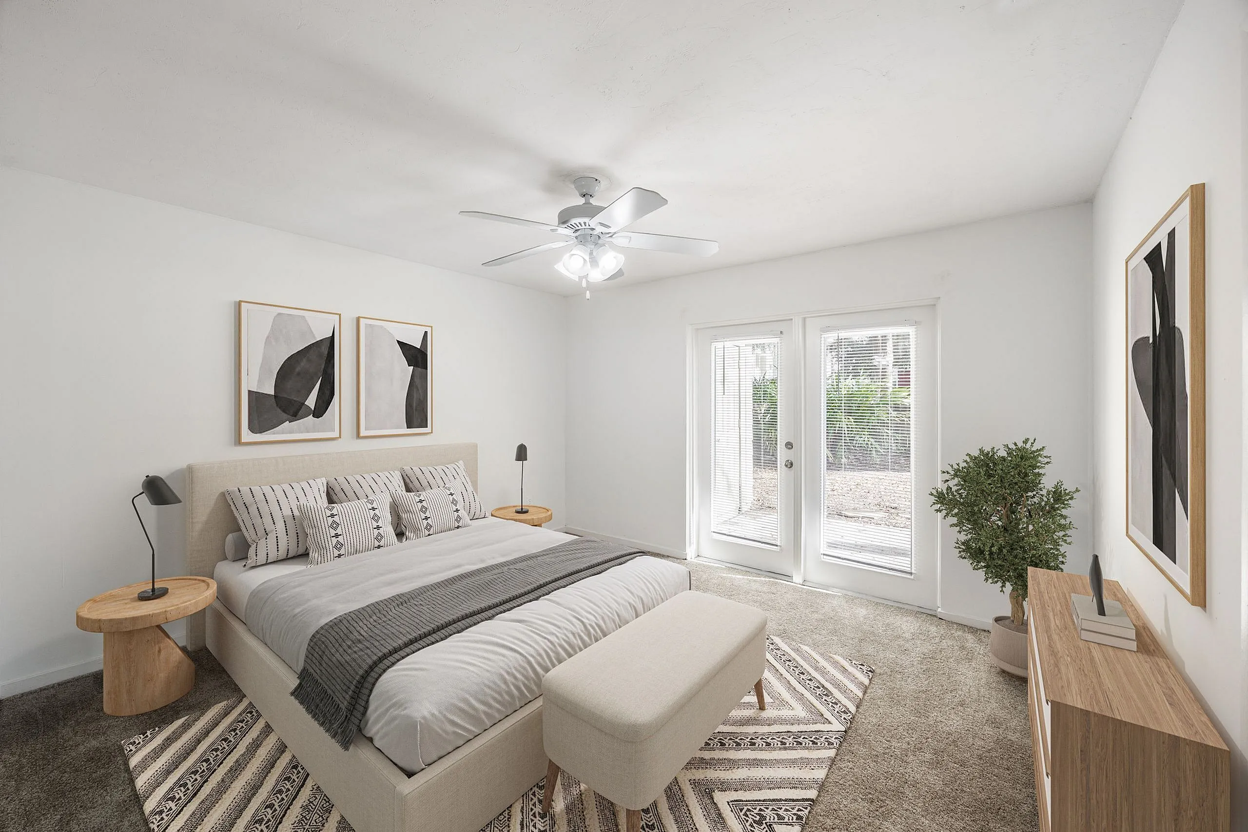 Elegantly furnished bedroom with a cozy bed, stylish decor, and natural light streaming through large glass doors.