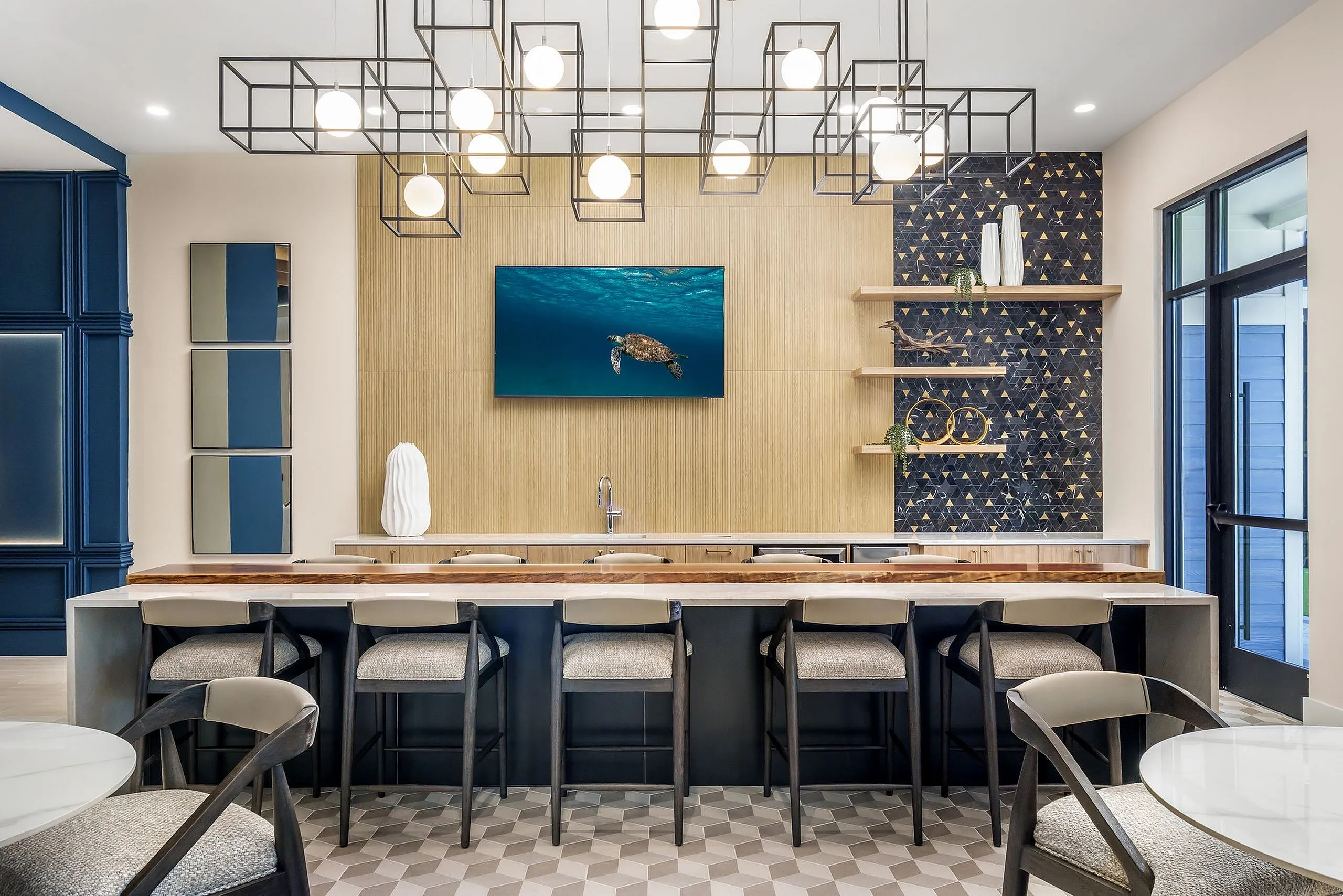 Sophisticated modern kitchen with geometric lighting, elegant bar seating, and a stylish turtle artwork centerpiece.
