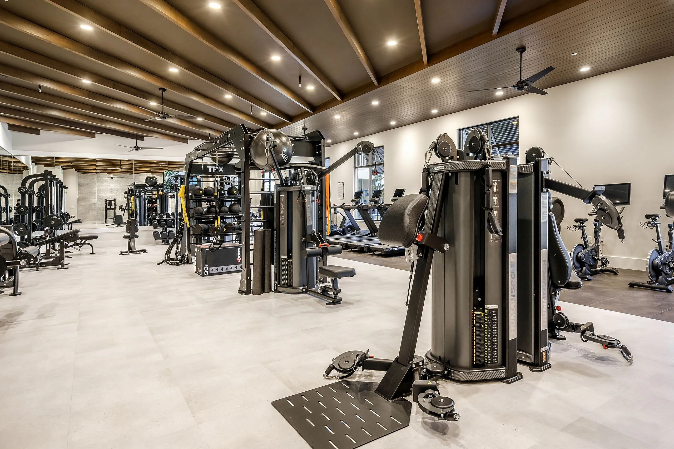 Modern fitness center featuring state-of-the-art exercise equipment, sleek design, and spacious workout areas.