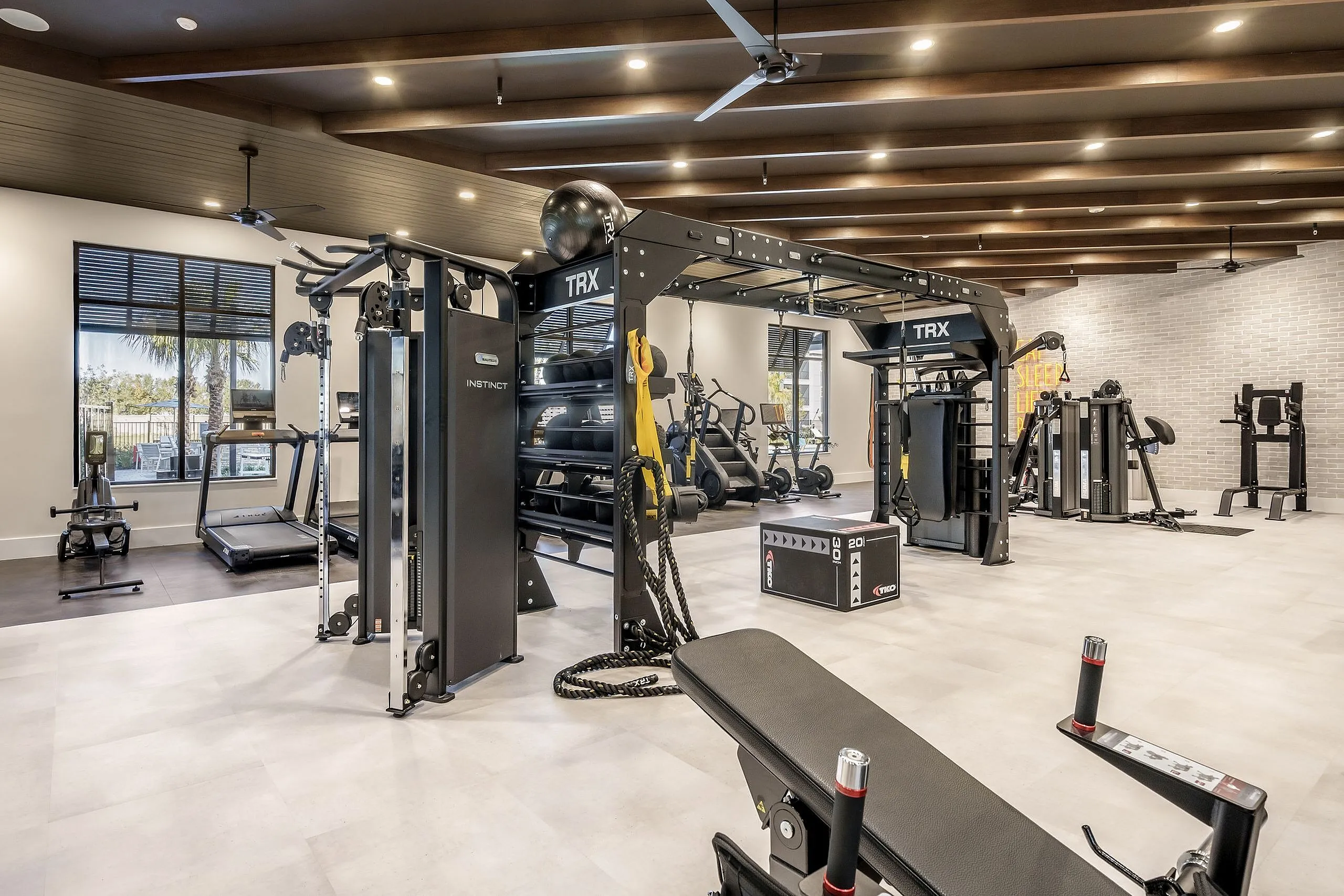Modern fitness center with TRX equipment, state-of-the-art machines, and natural lighting for an invigorating workout experience.