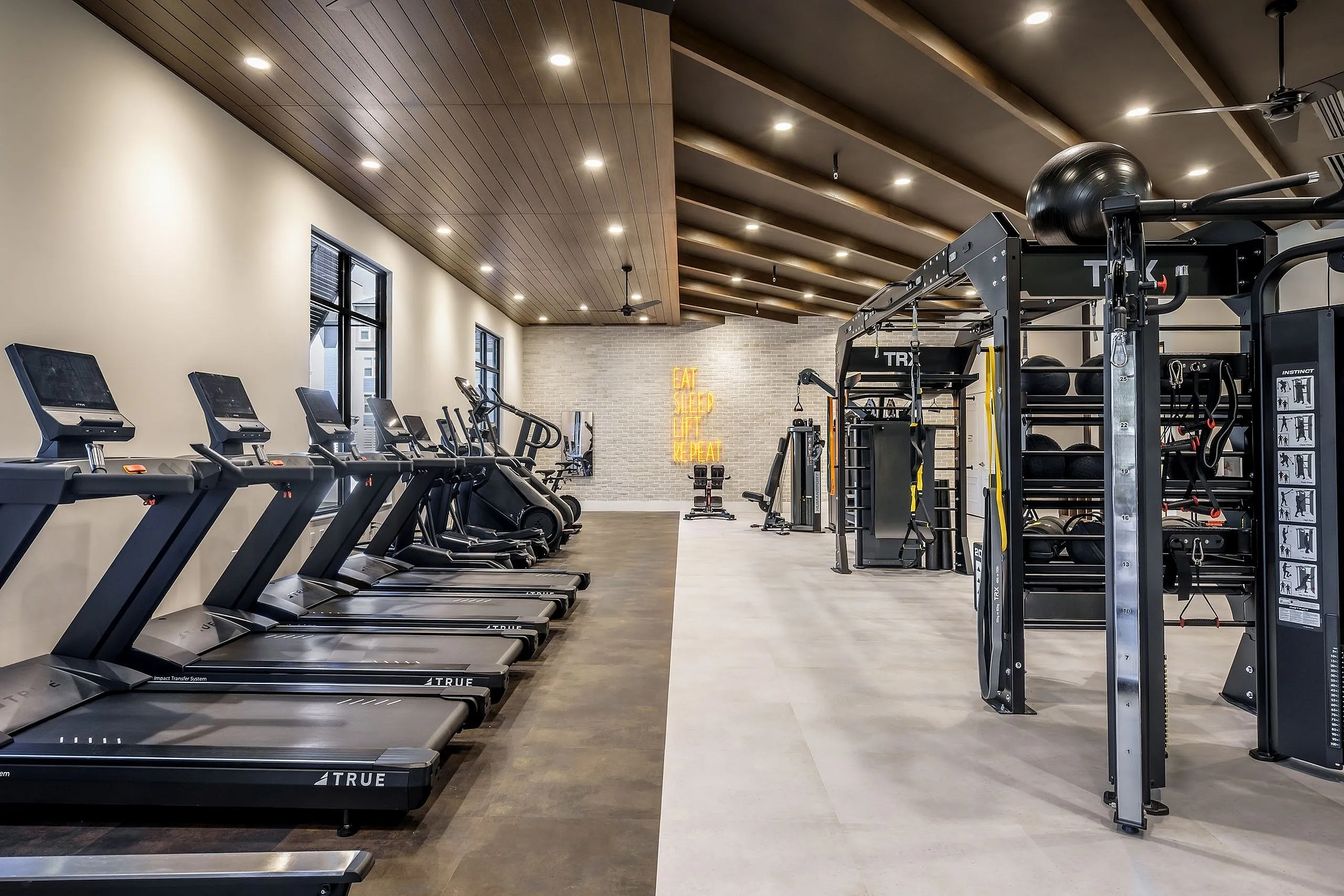 Modern fitness center featuring state-of-the-art treadmills, strength training equipment, and motivational wall art, perfect for an invigorating workout.