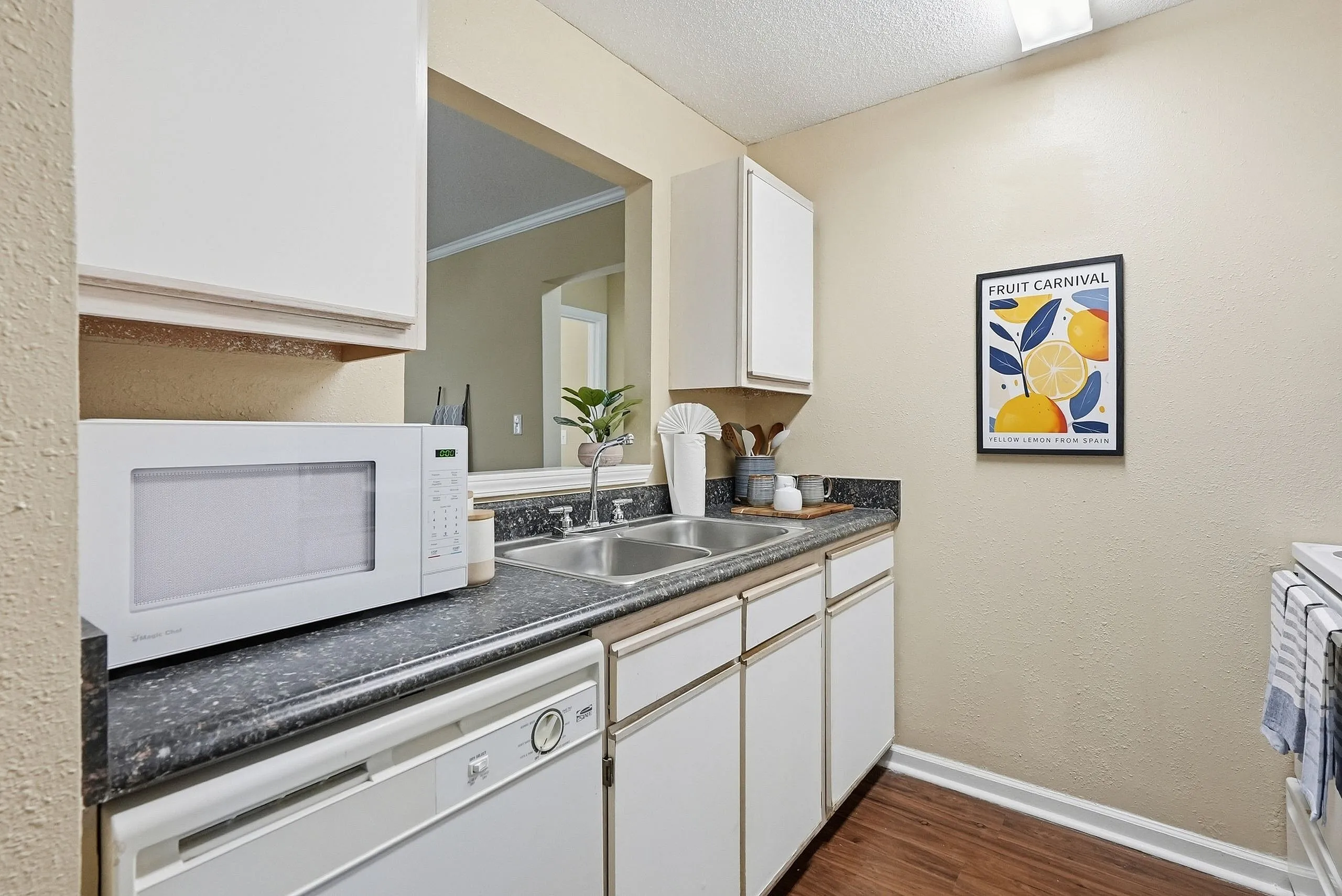Charming kitchen featuring sleek countertops, modern microwave, and vibrant decor.