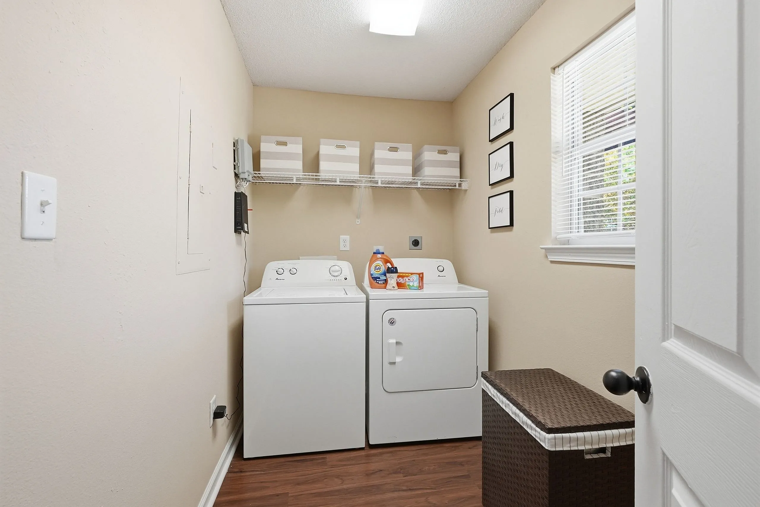 Charming laundry room featuring modern washer and dryer, with efficient storage solutions and elegant decor accents.