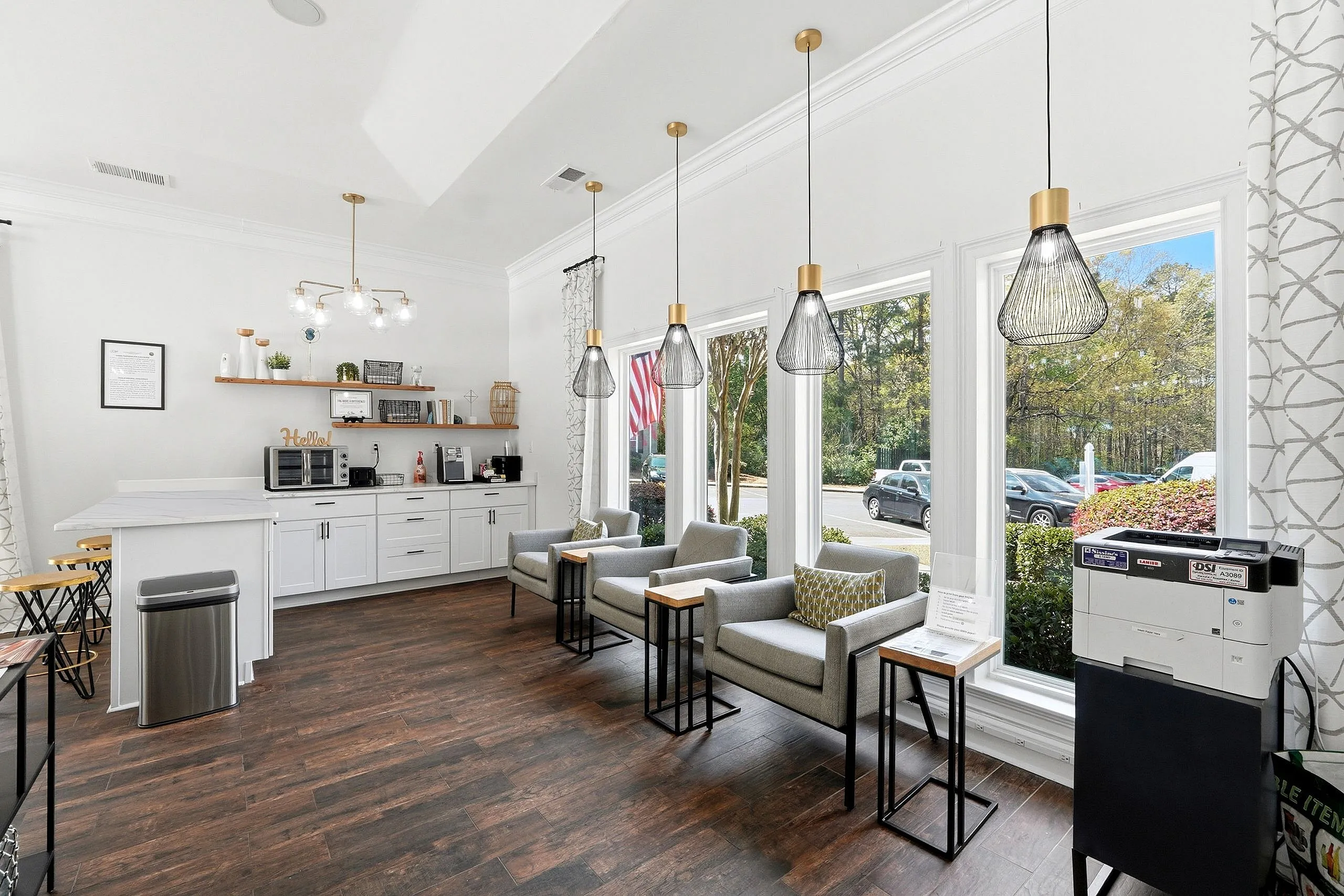 Chic and inviting communal space with modern kitchen facilities, cozy seating, and large windows offering a serene outdoor view.