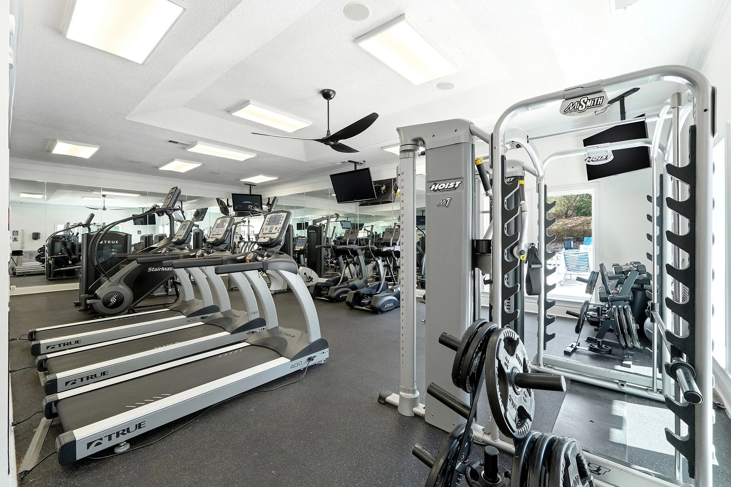 Modern fitness center featuring state-of-the-art equipment, including treadmills, weight machines, and a sleek contemporary design.