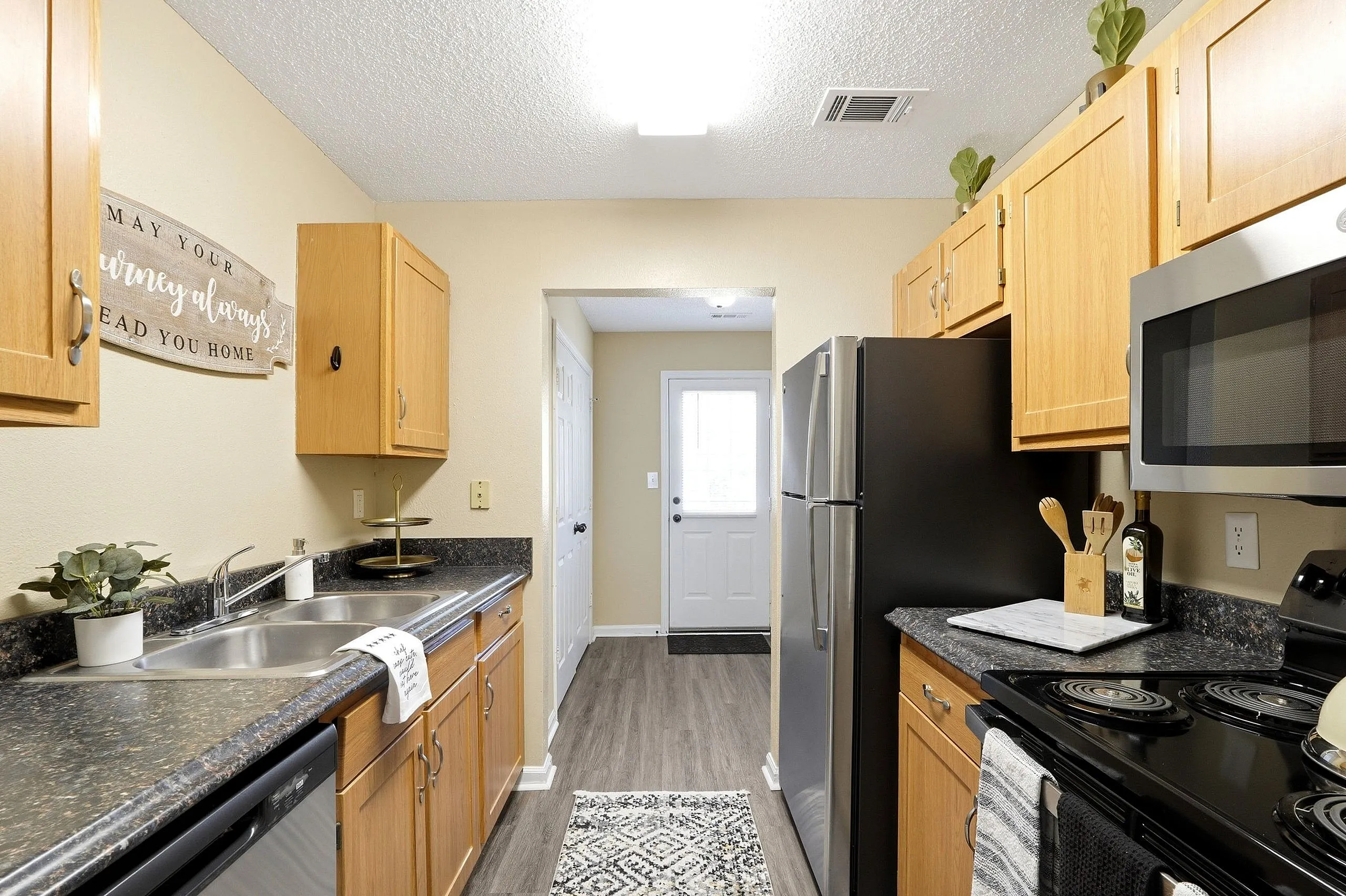 Charming kitchen with modern appliances, wood cabinets, and sleek countertops, offering a warm and inviting atmosphere.