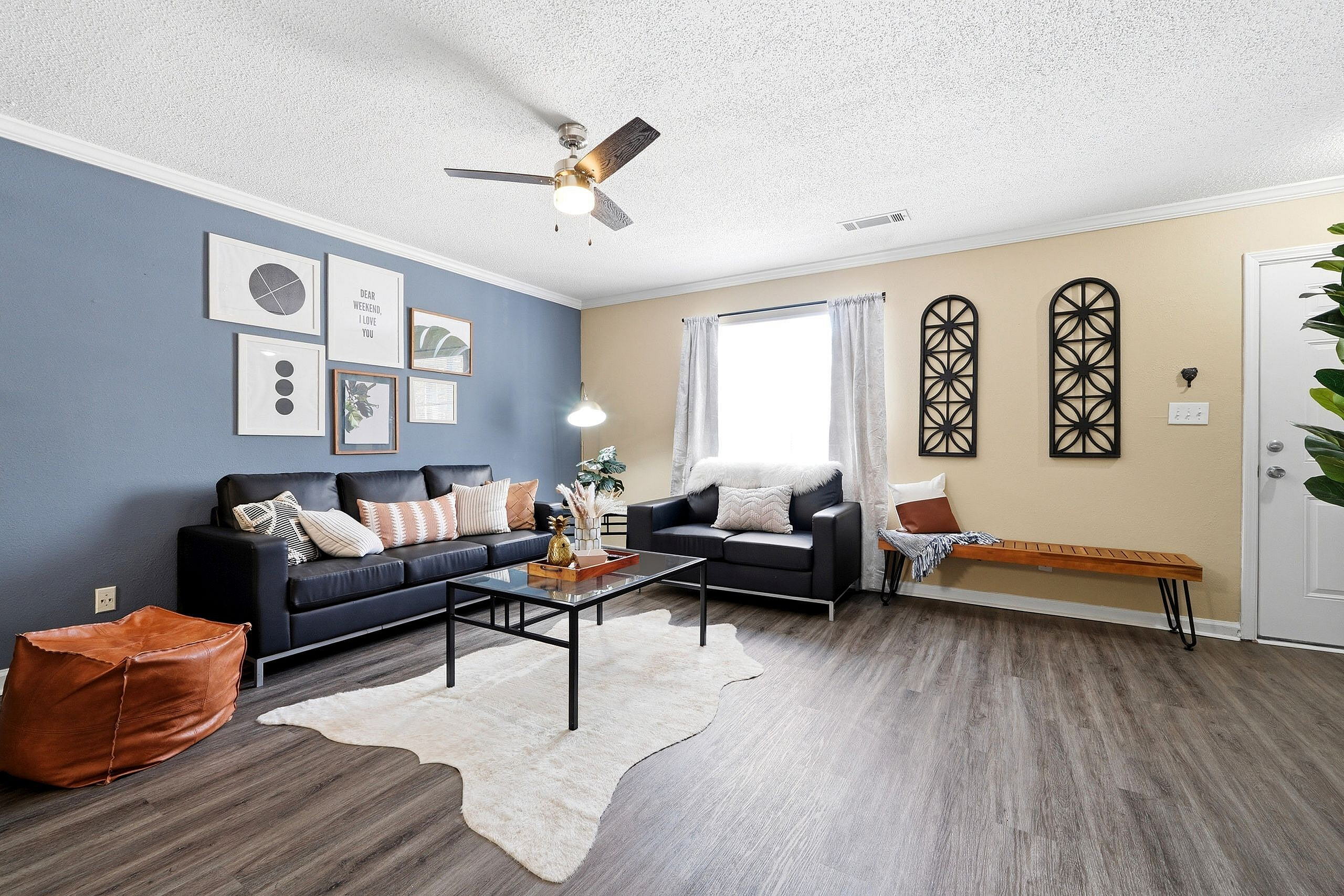 Modern living room with stylish navy and beige color scheme, plush seating, chic wall art, and a cozy ambiance.