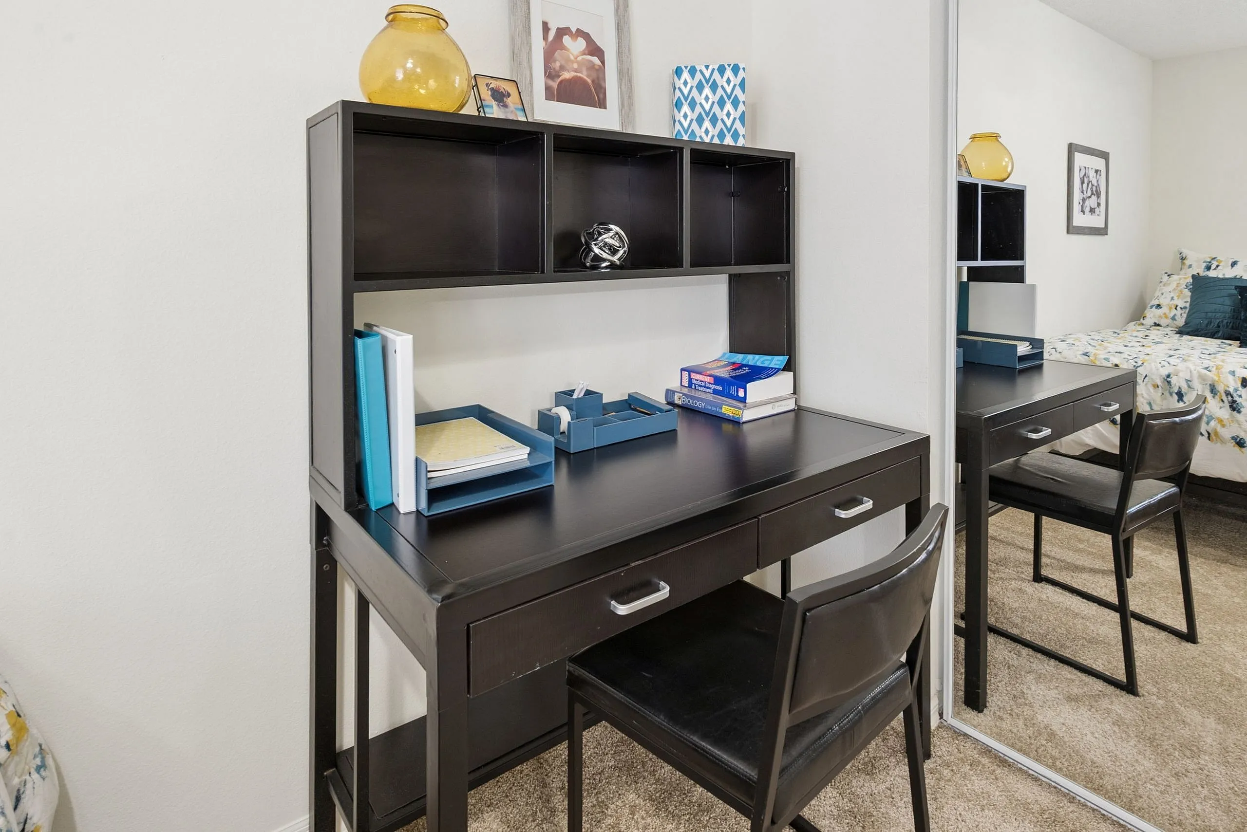 Contemporary workspace featuring a sleek black desk with ample shelving, ideal for productivity and style.