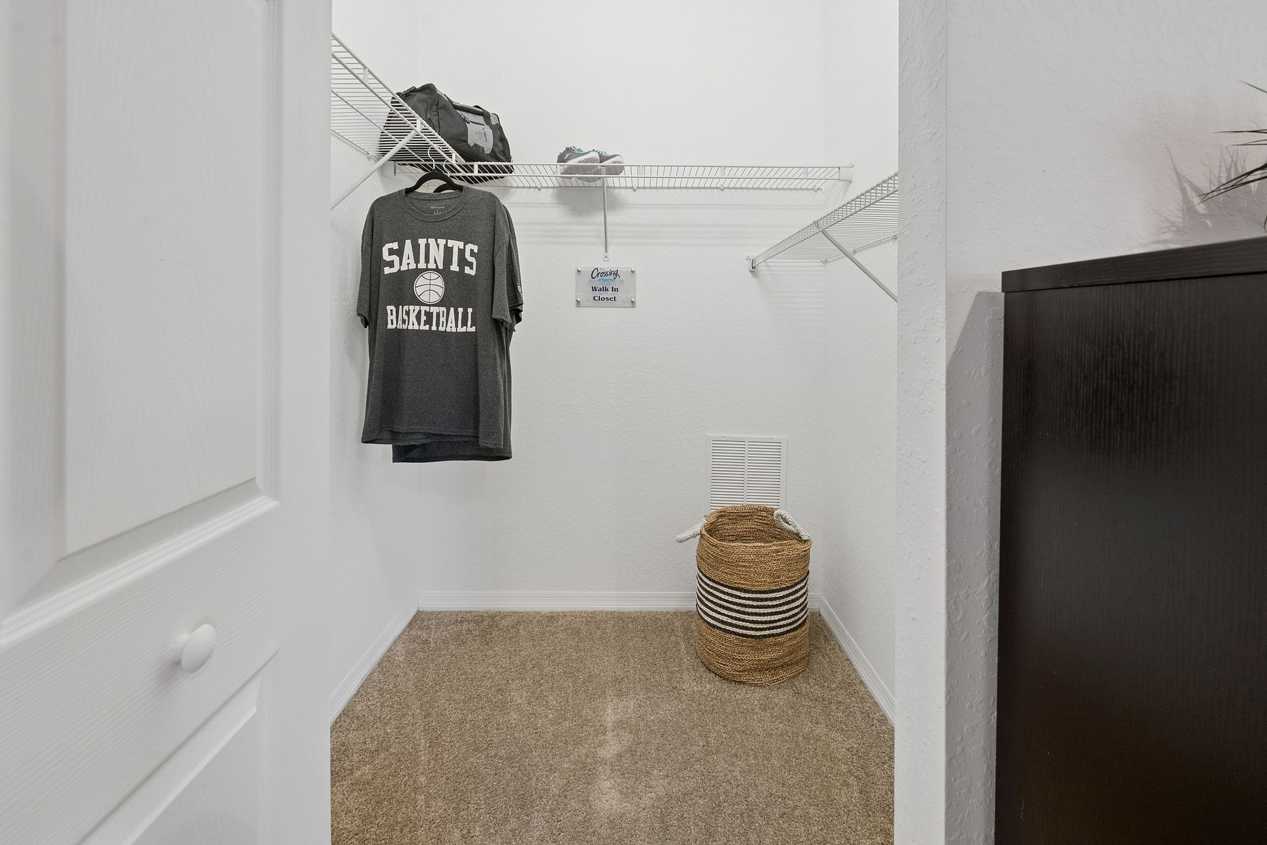 Spacious walk-in closet with sleek shelving, cozy carpeting, and ample storage space.