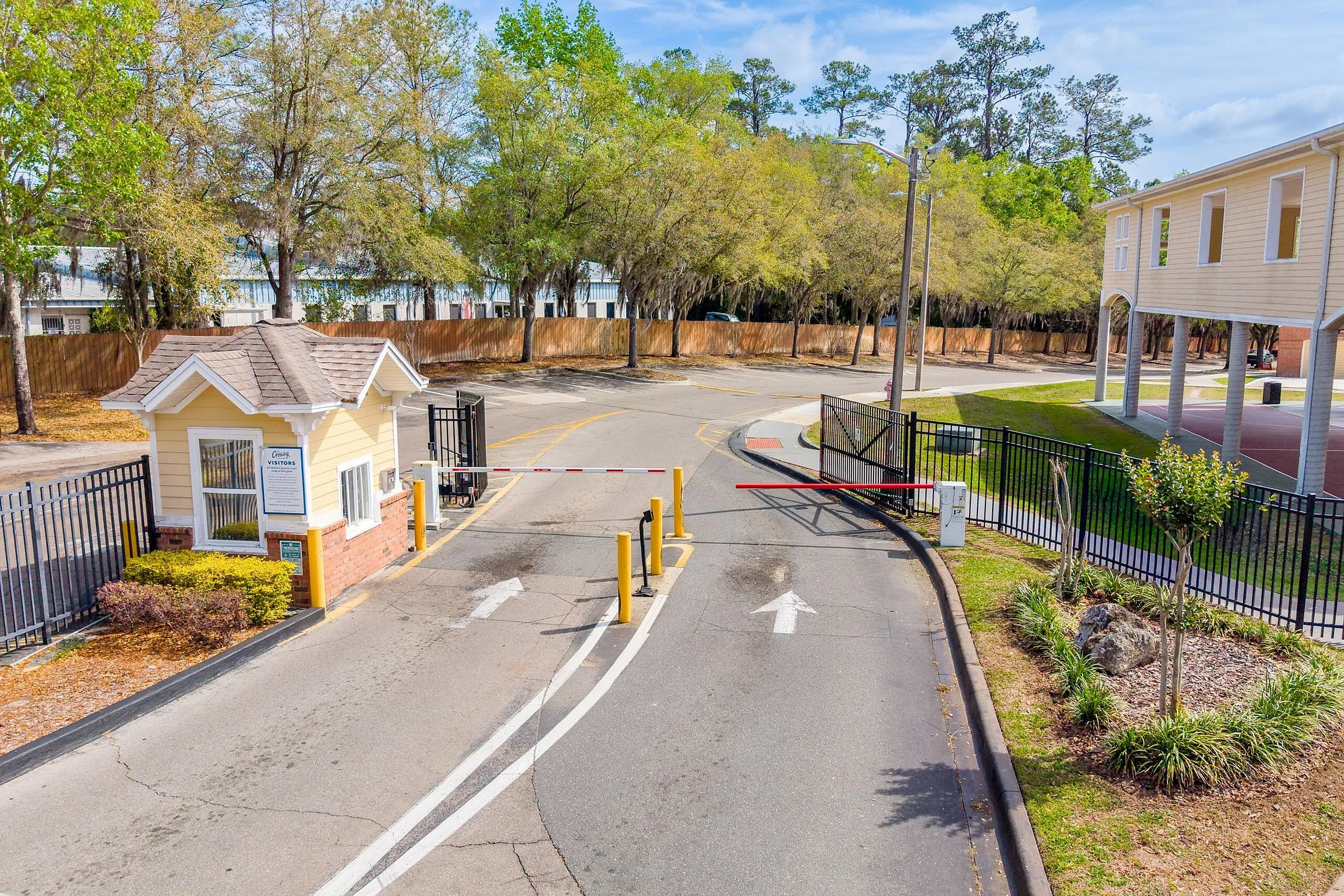 Inviting entrance to a vibrant community with lush greenery and secure gated access.