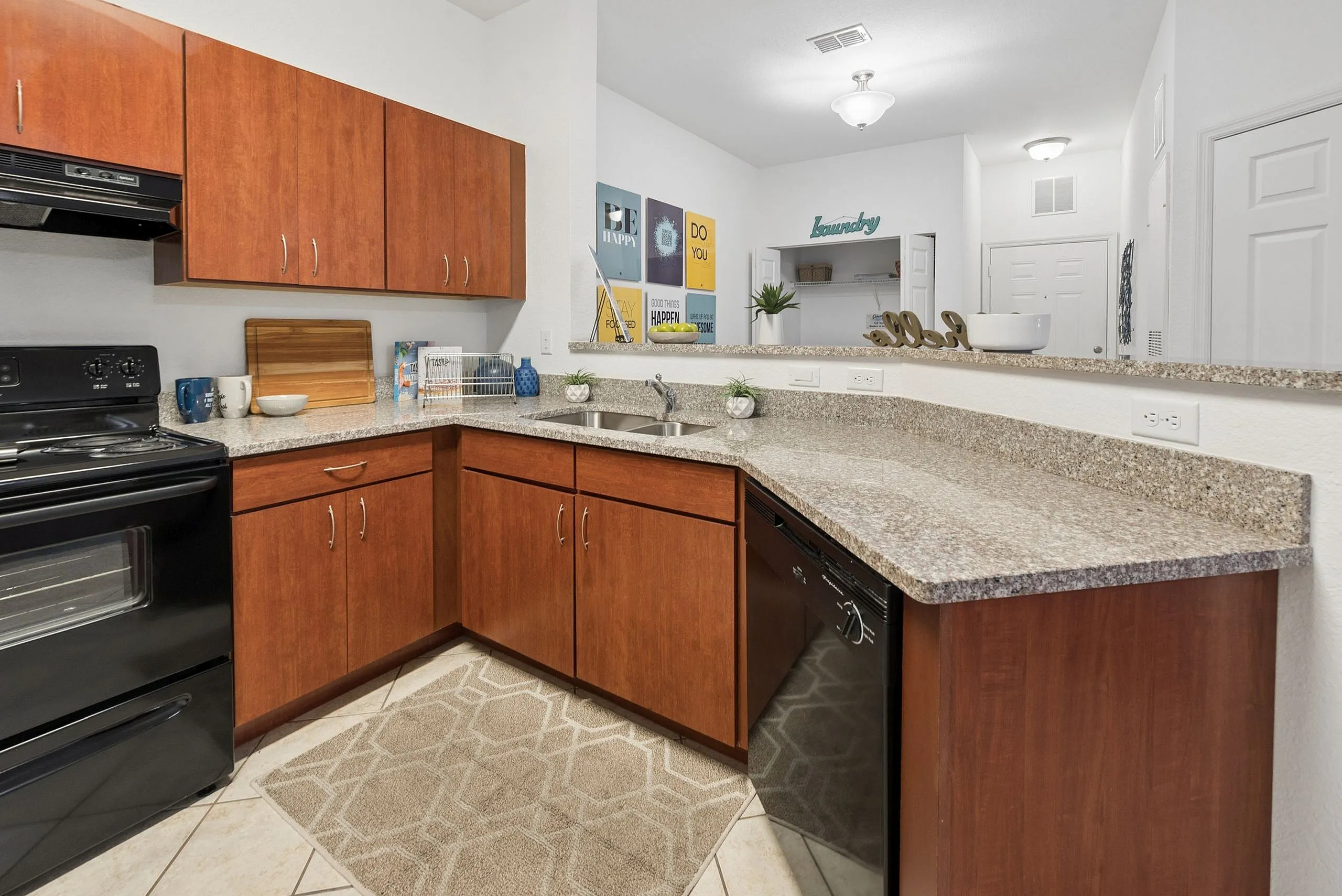 Modern kitchen with sleek black appliances, granite countertops, and rich wood cabinetry, offering a warm and inviting cooking space.
