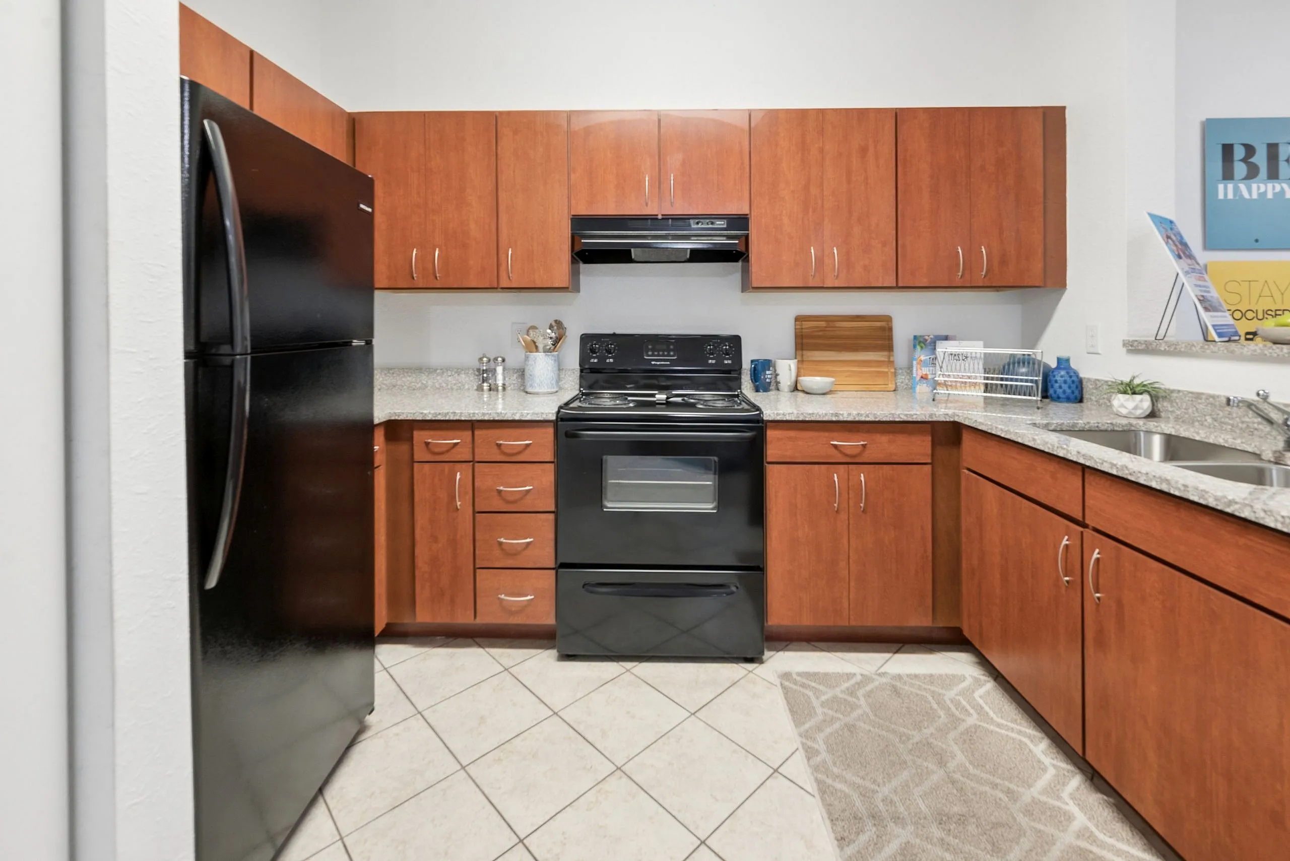 Modern kitchen with sleek black appliances, rich wooden cabinetry, and granite countertops for an elegant cooking space.