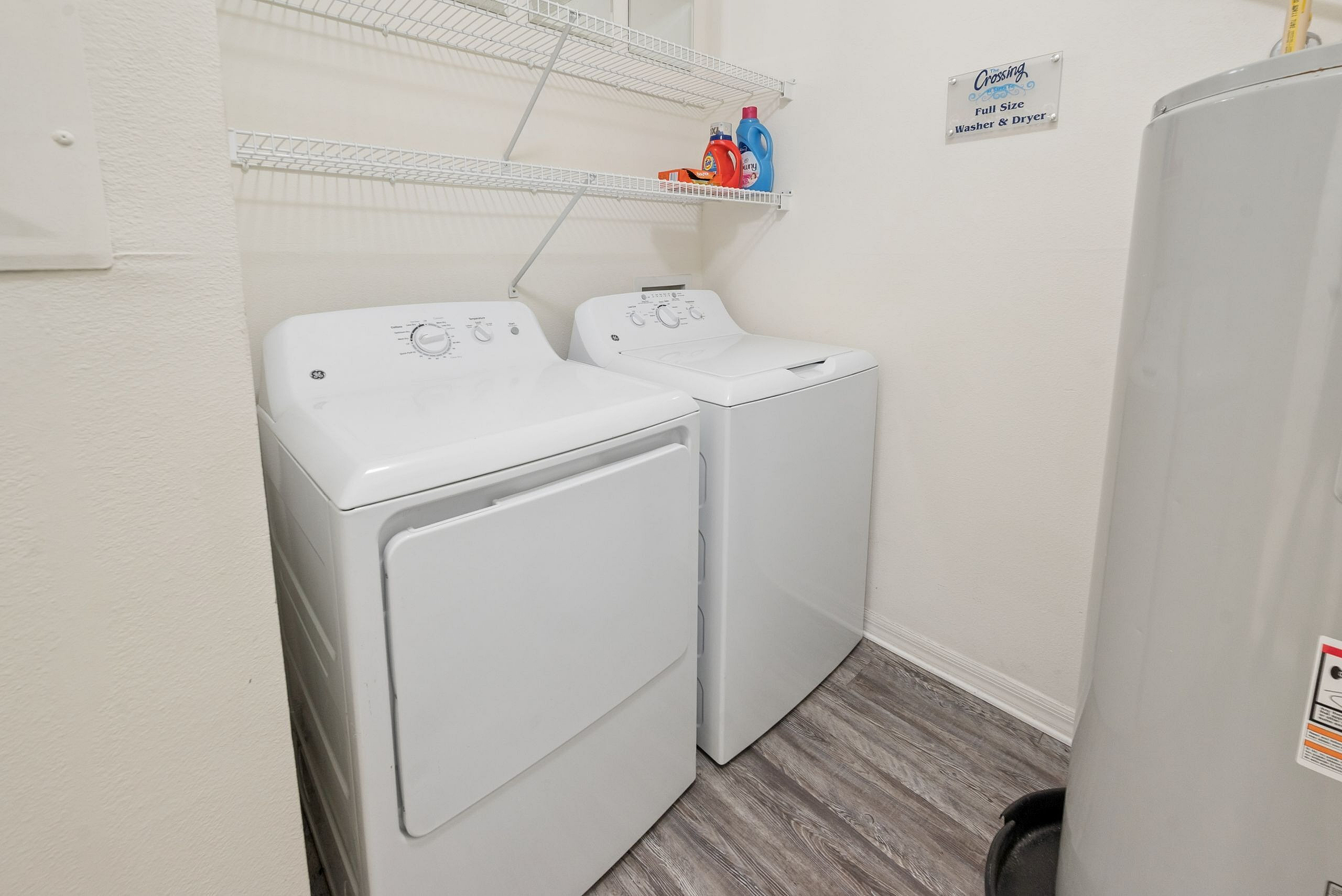Efficient laundry space with modern washer and dryer, featuring stylish shelving for organization.