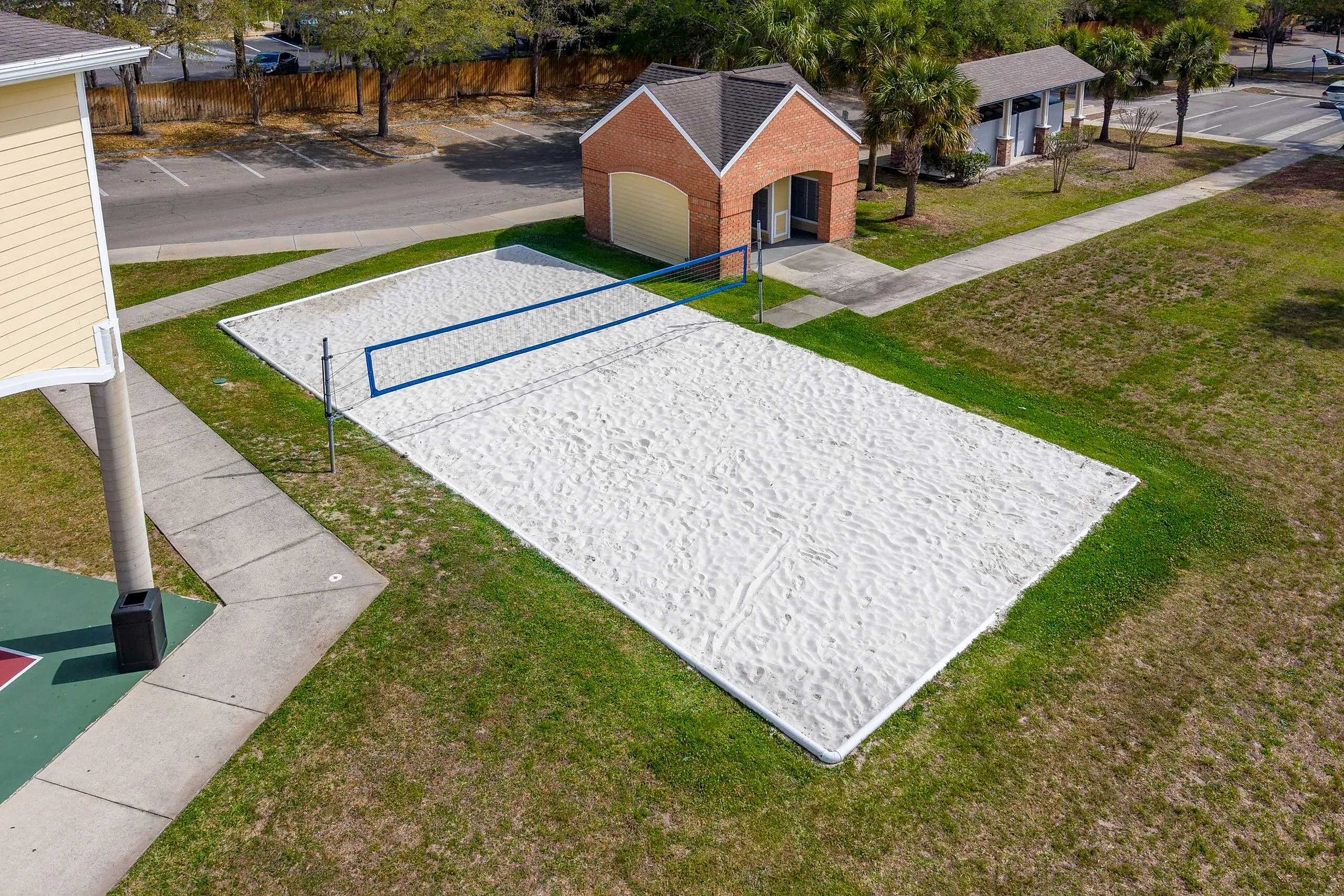 Inviting sand volleyball court set beside a charming brick building, perfect for outdoor recreation and relaxation.