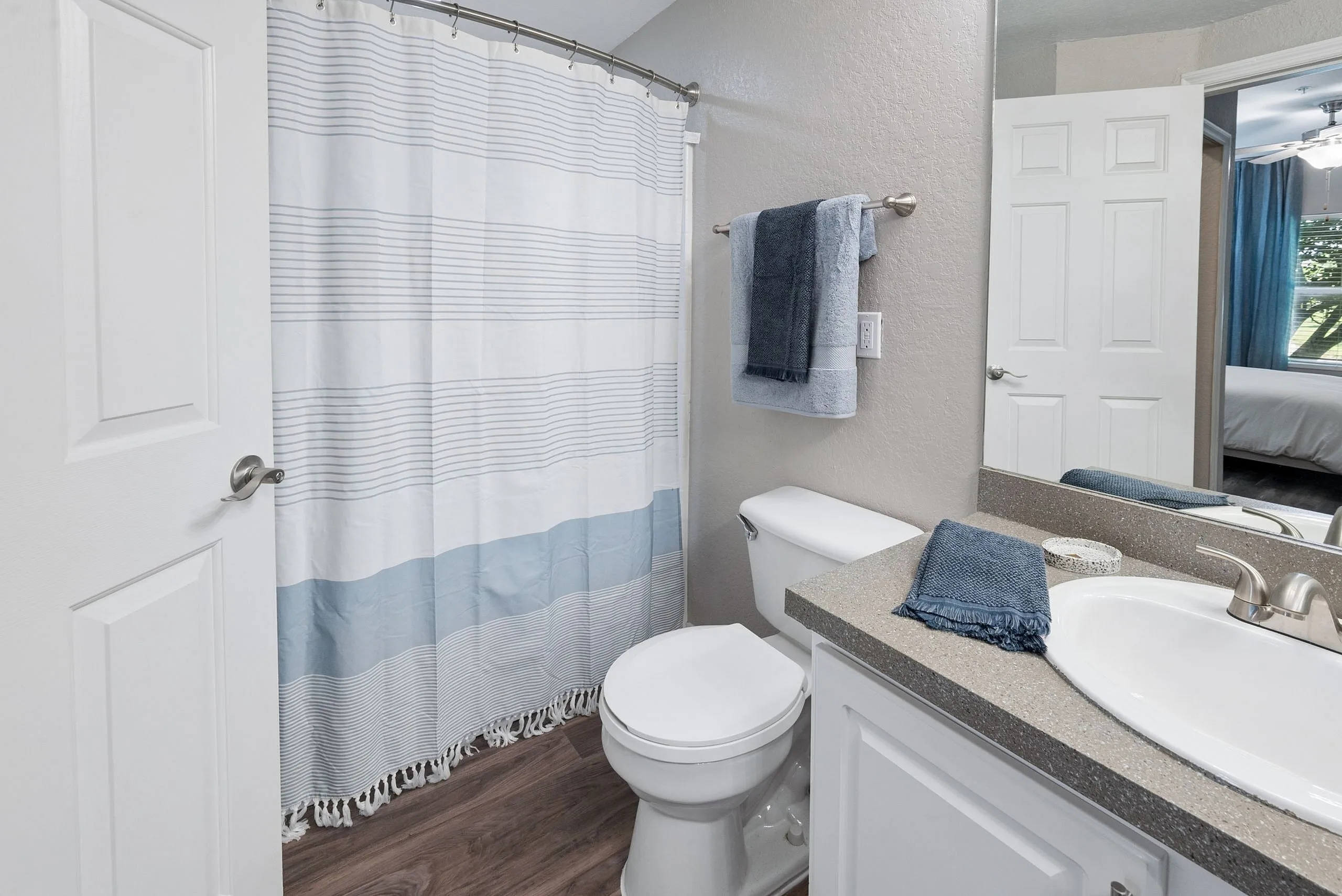 Elegant bathroom featuring a modern sink, stylish countertop, and a chic blue and white shower curtain. The cozy ambiance is enhanced by soft lighting and high-quality fixtures.