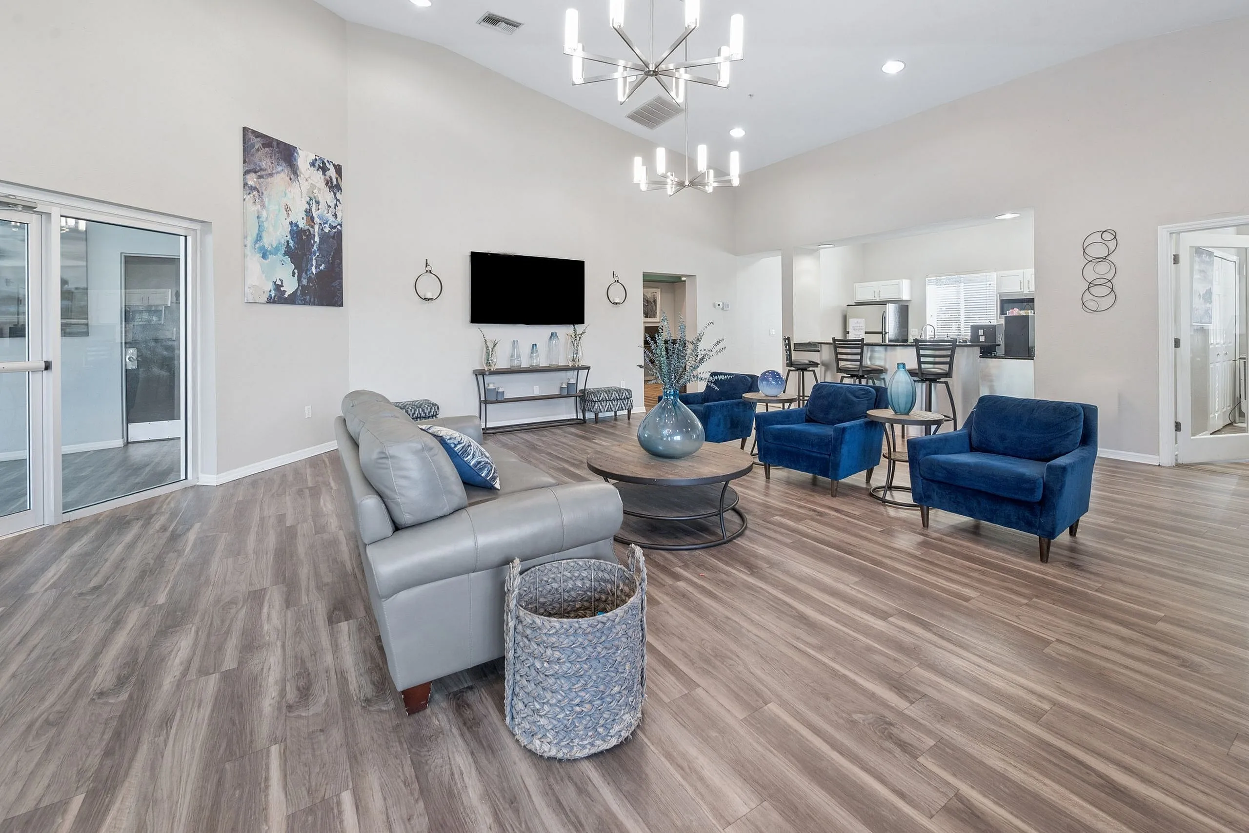 Chic open-concept living space with stylish furniture, modern lighting, and a sleek kitchen area, offering comfort and elegance.