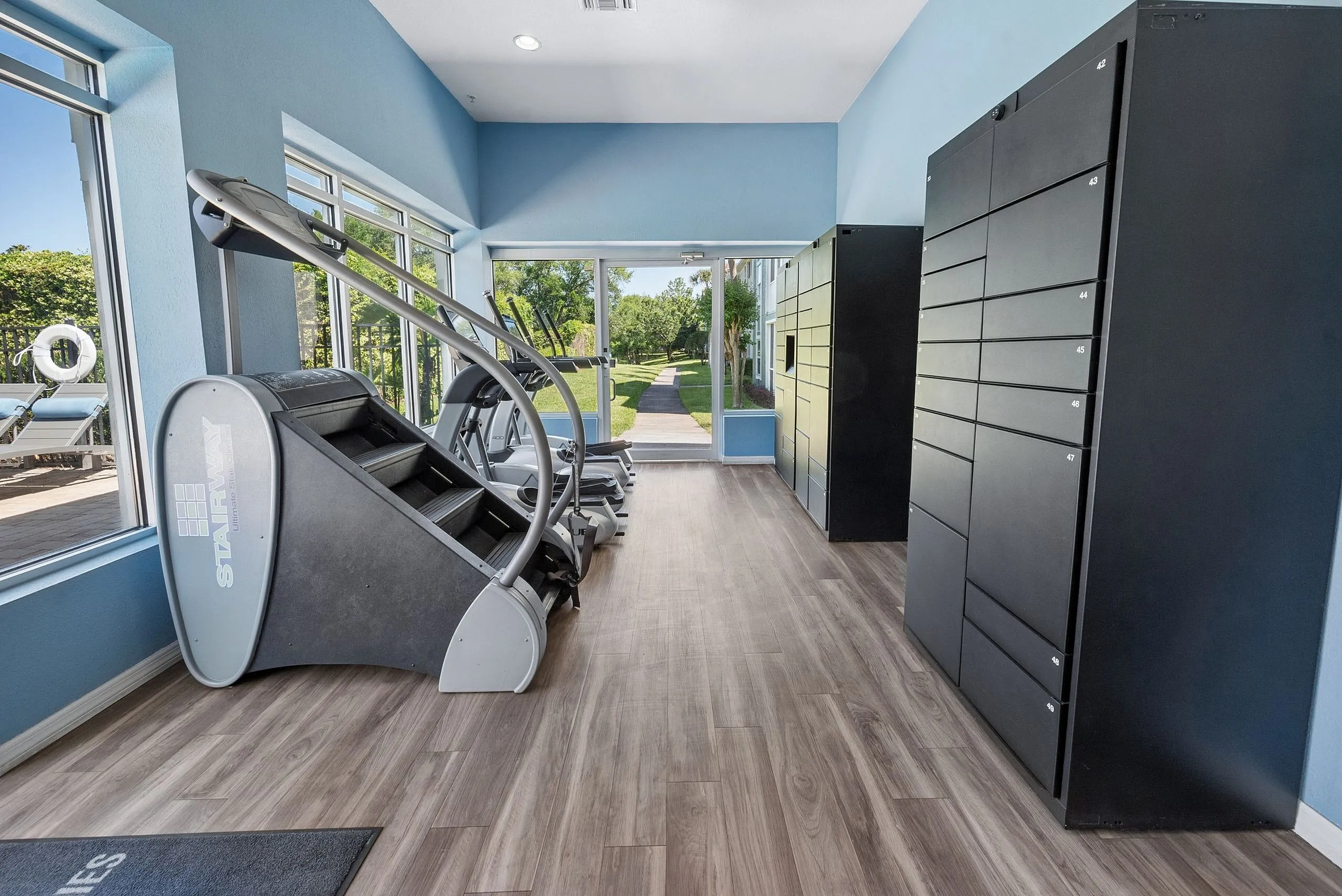 Bright and modern fitness area with state-of-the-art equipment, large windows, and scenic views.
