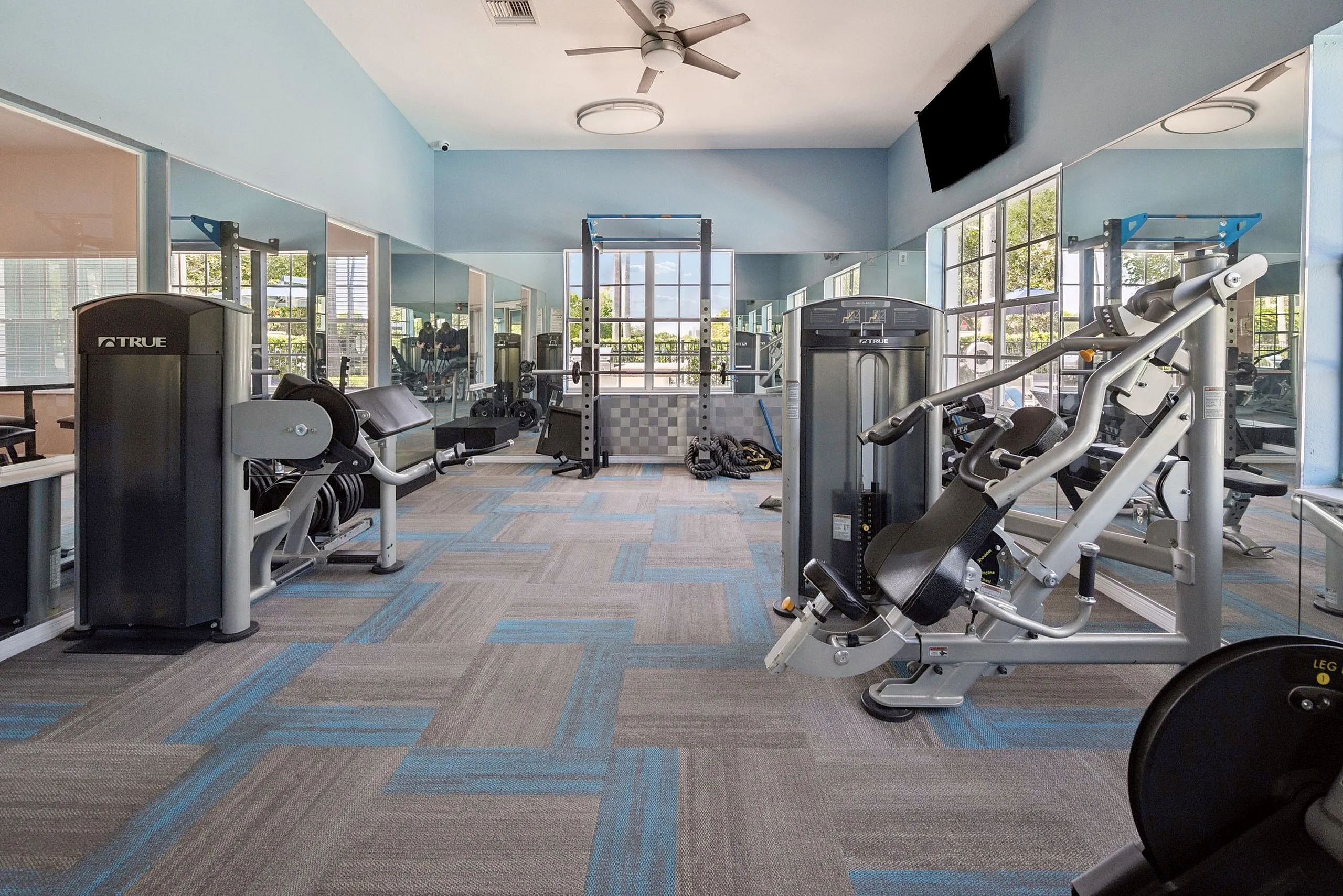 Modern fitness center with state-of-the-art gym equipment and floor-to-ceiling mirrors, offering a bright and inviting workout space.