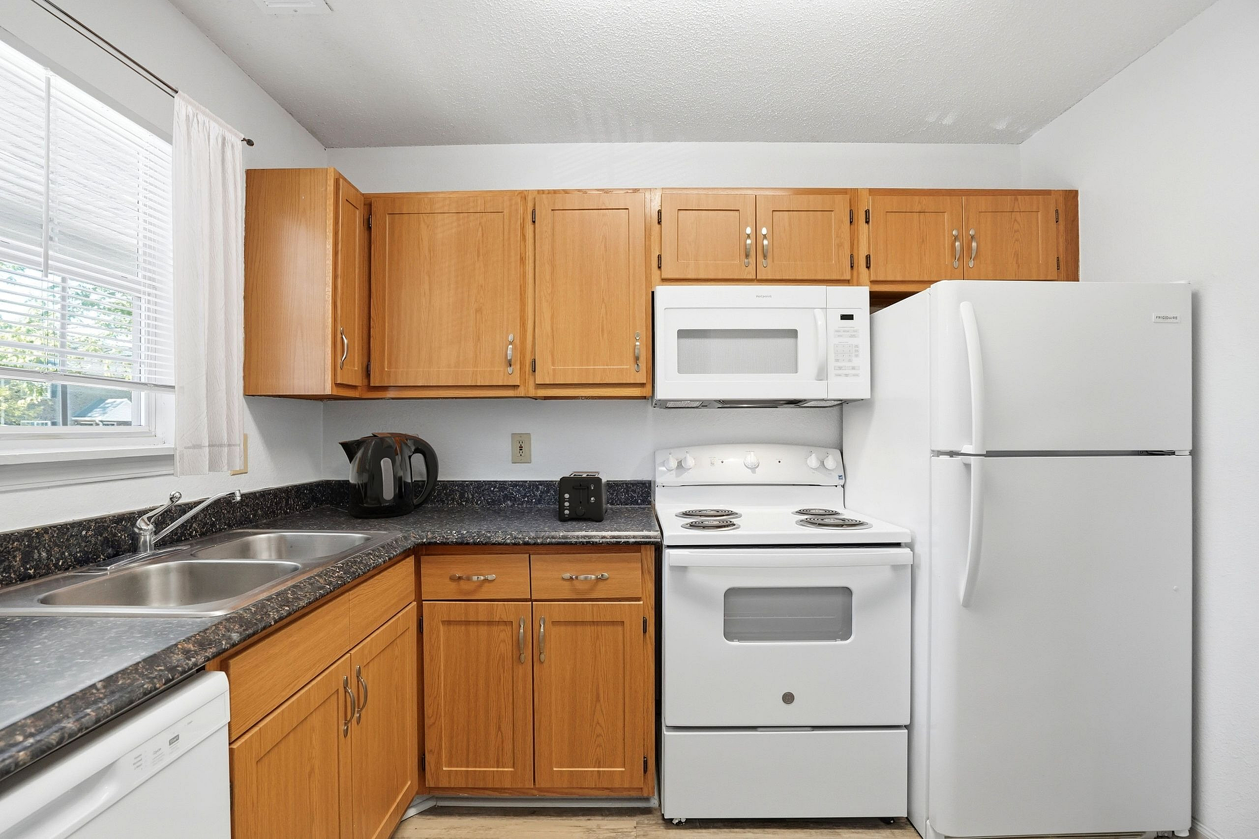 Charming kitchen with sleek countertops, modern appliances, and elegant wooden cabinetry.