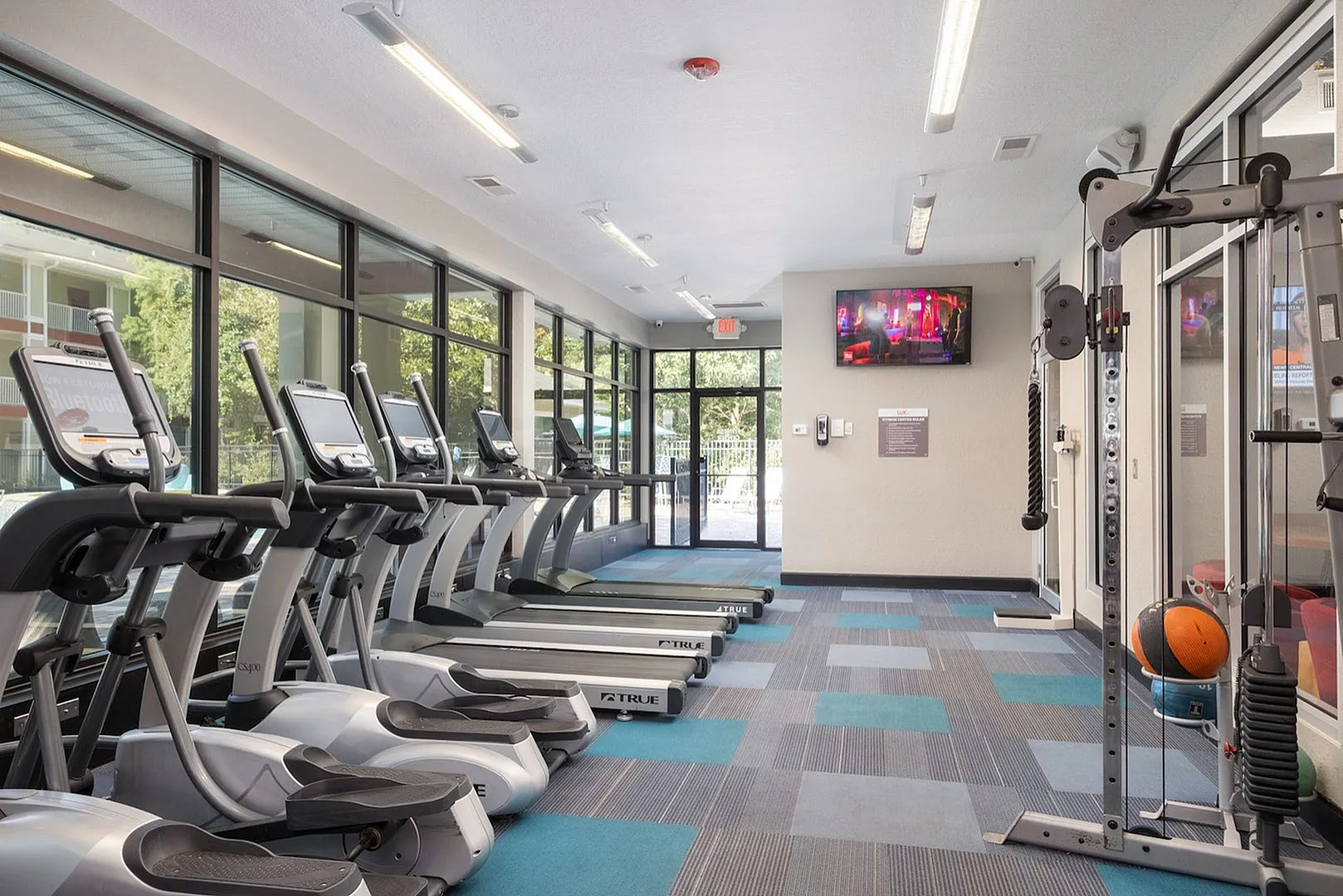Spacious fitness center with modern treadmills overlooking a scenic view, ideal for an energizing workout experience.