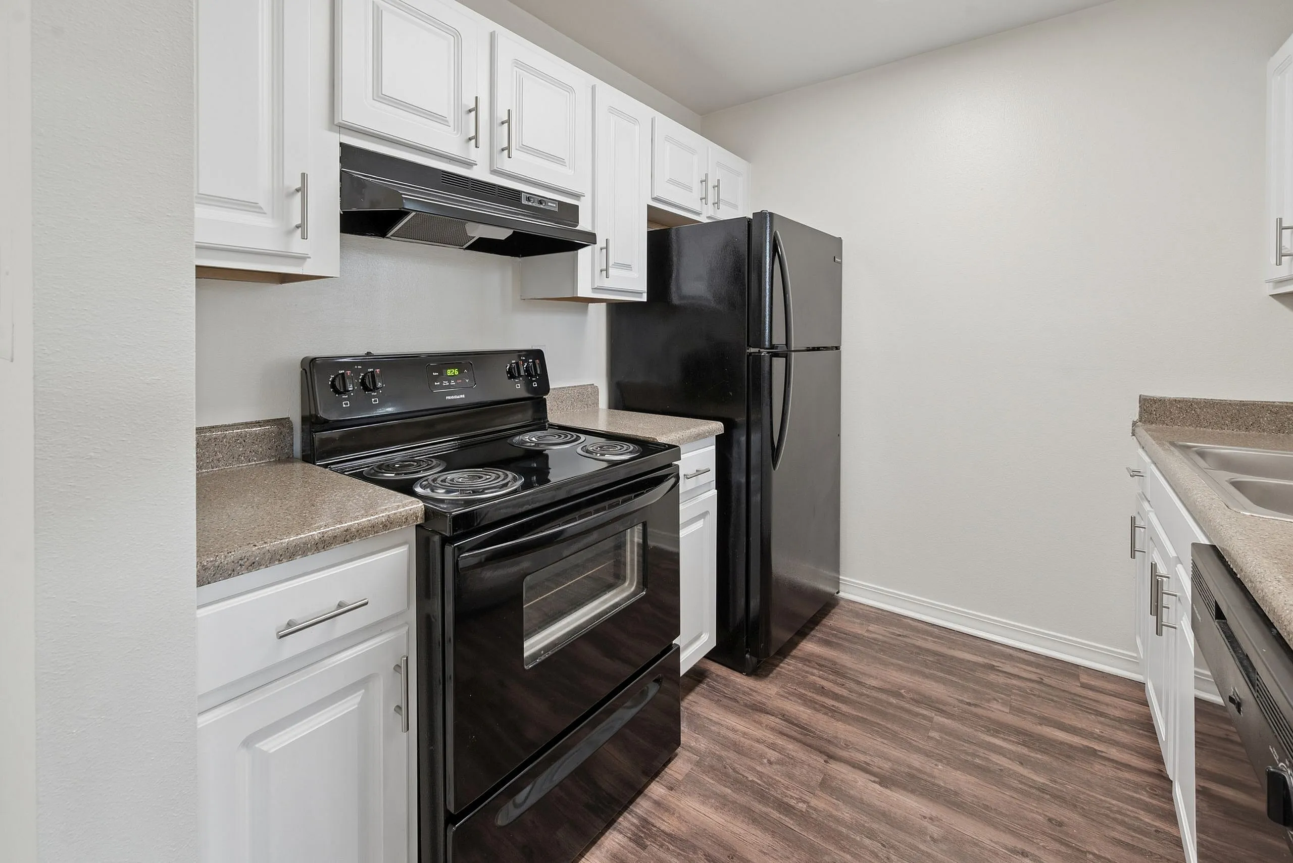 Modern kitchen featuring sleek black appliances, elegant white cabinetry, and durable countertops, perfect for culinary enthusiasts.