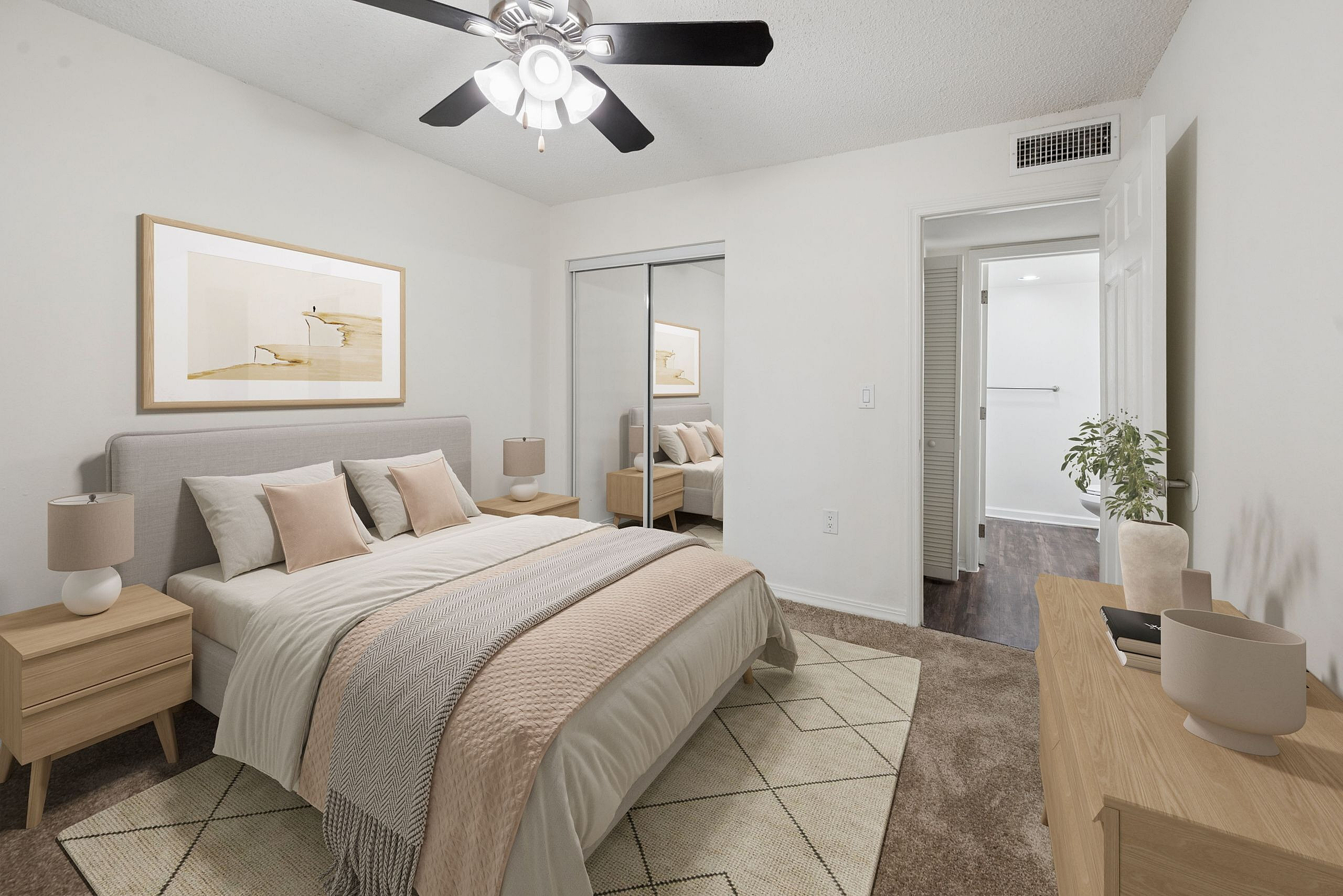 Elegant bedroom with neutral tones, featuring a plush bed, mirrored closet, and modern ceiling fan.