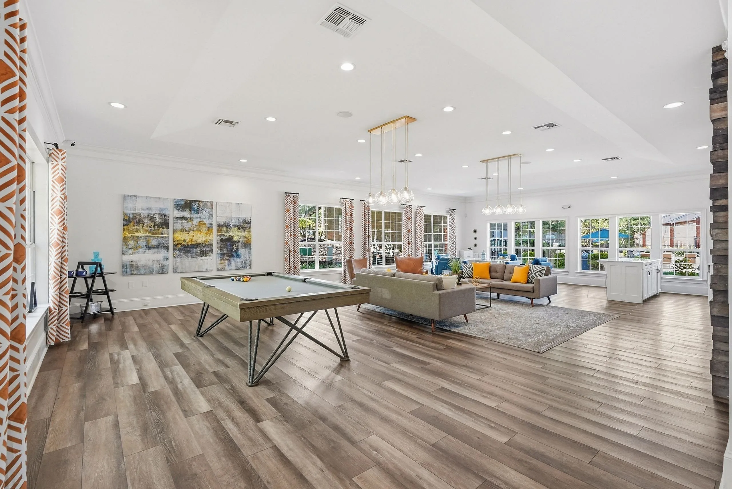 Spacious and inviting living area featuring modern decor, a pool table, and elegant lighting, perfect for entertaining and relaxation.