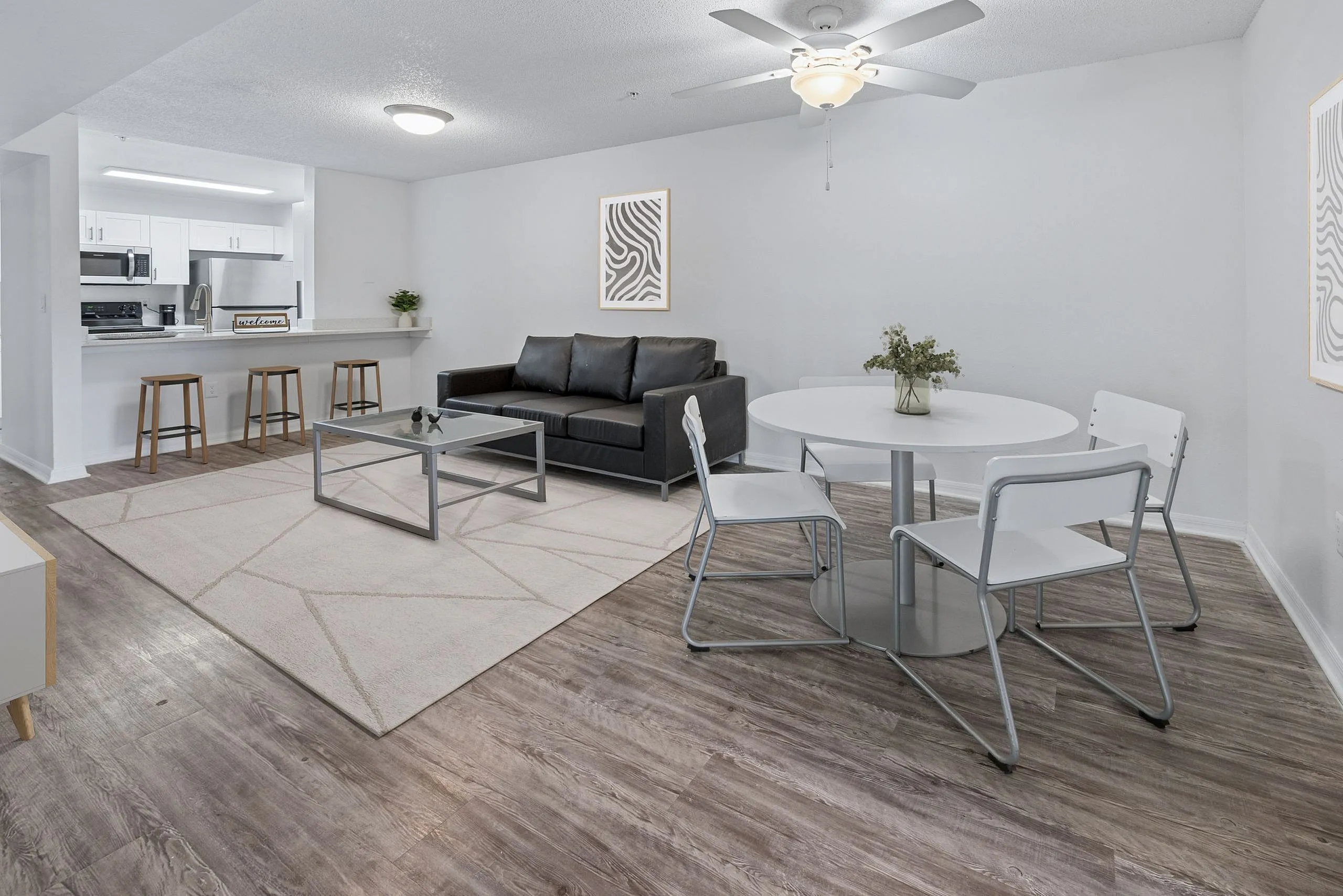 Chic open-concept living area with a modern kitchen, elegant dining space, and cozy living room featuring sleek furniture and contemporary decor.