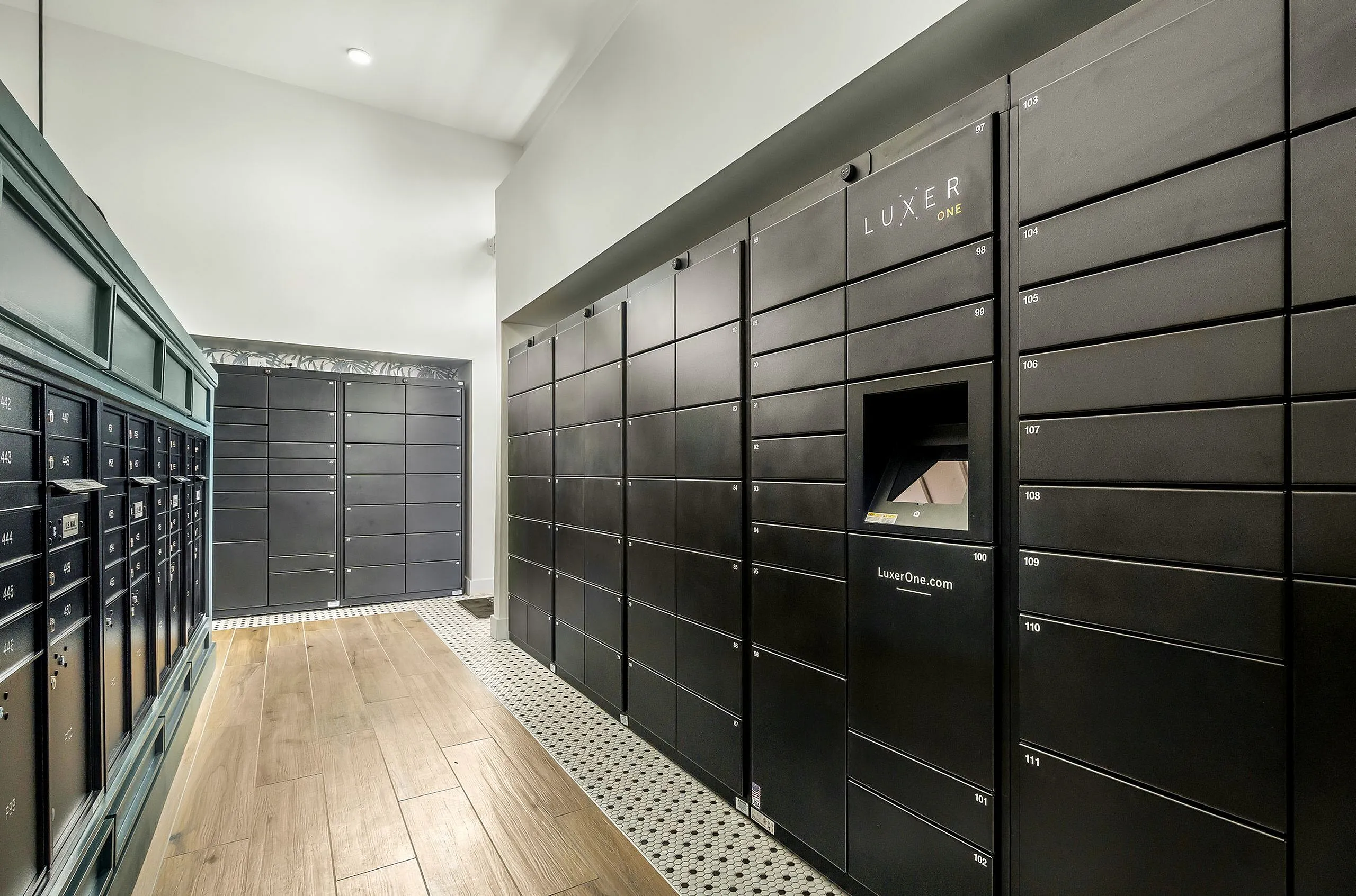 Modern package locker system in a sleek apartment building, featuring secure Luxer One lockers and elegant wood flooring.