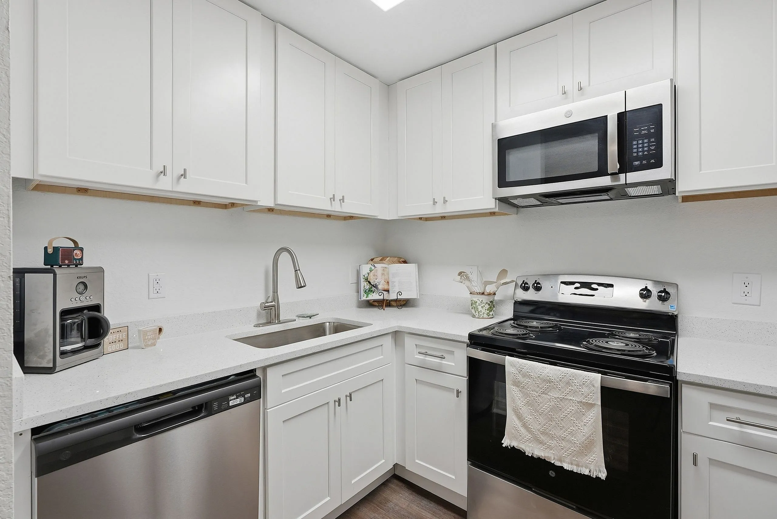Modern kitchen with sleek white cabinetry, stainless steel appliances, and elegant quartz countertops.