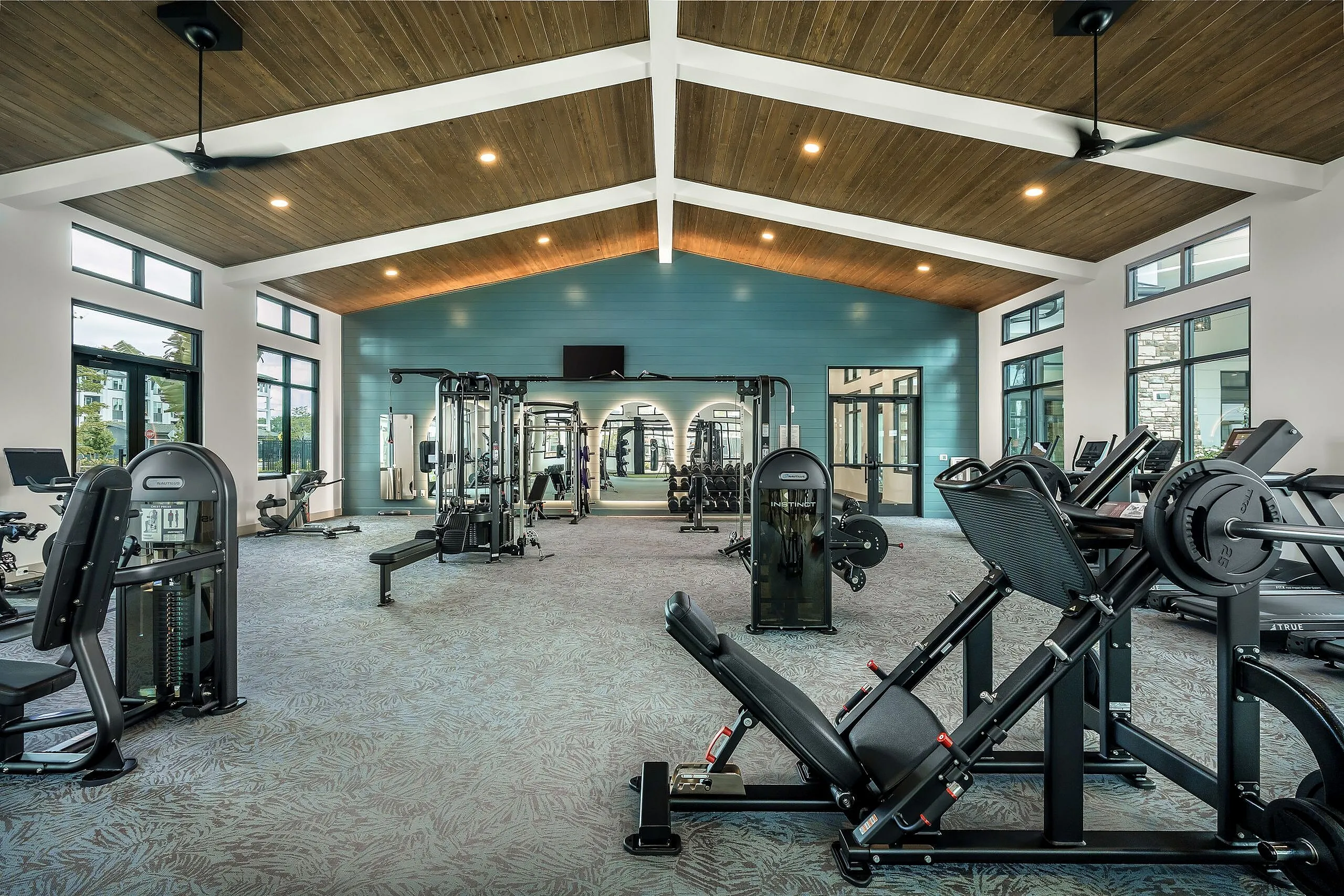 Modern fitness center with state-of-the-art equipment, high ceilings, and natural lighting for a vibrant workout experience.
