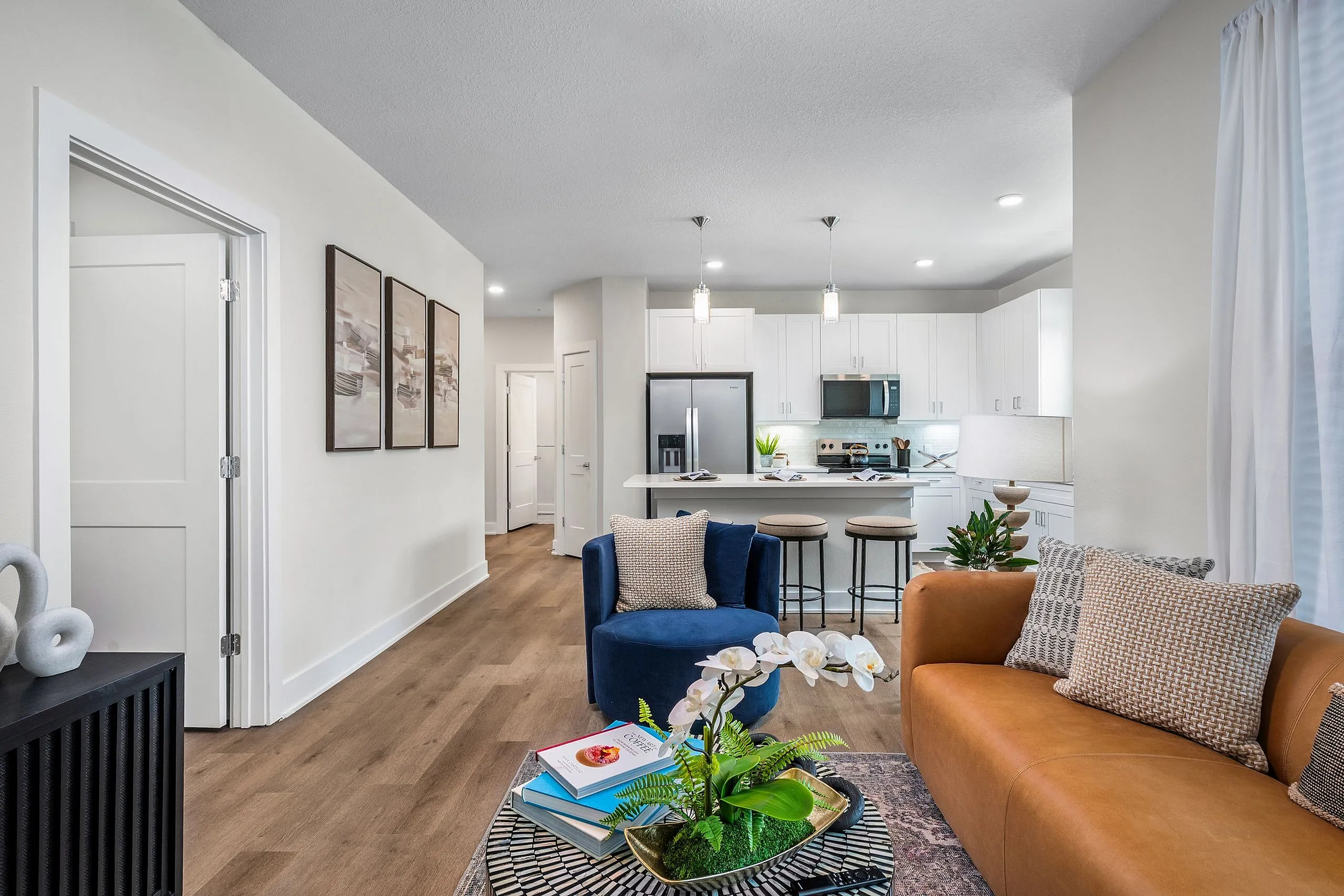 Contemporary open-concept living space with stylish kitchen, plush seating, and modern decor.