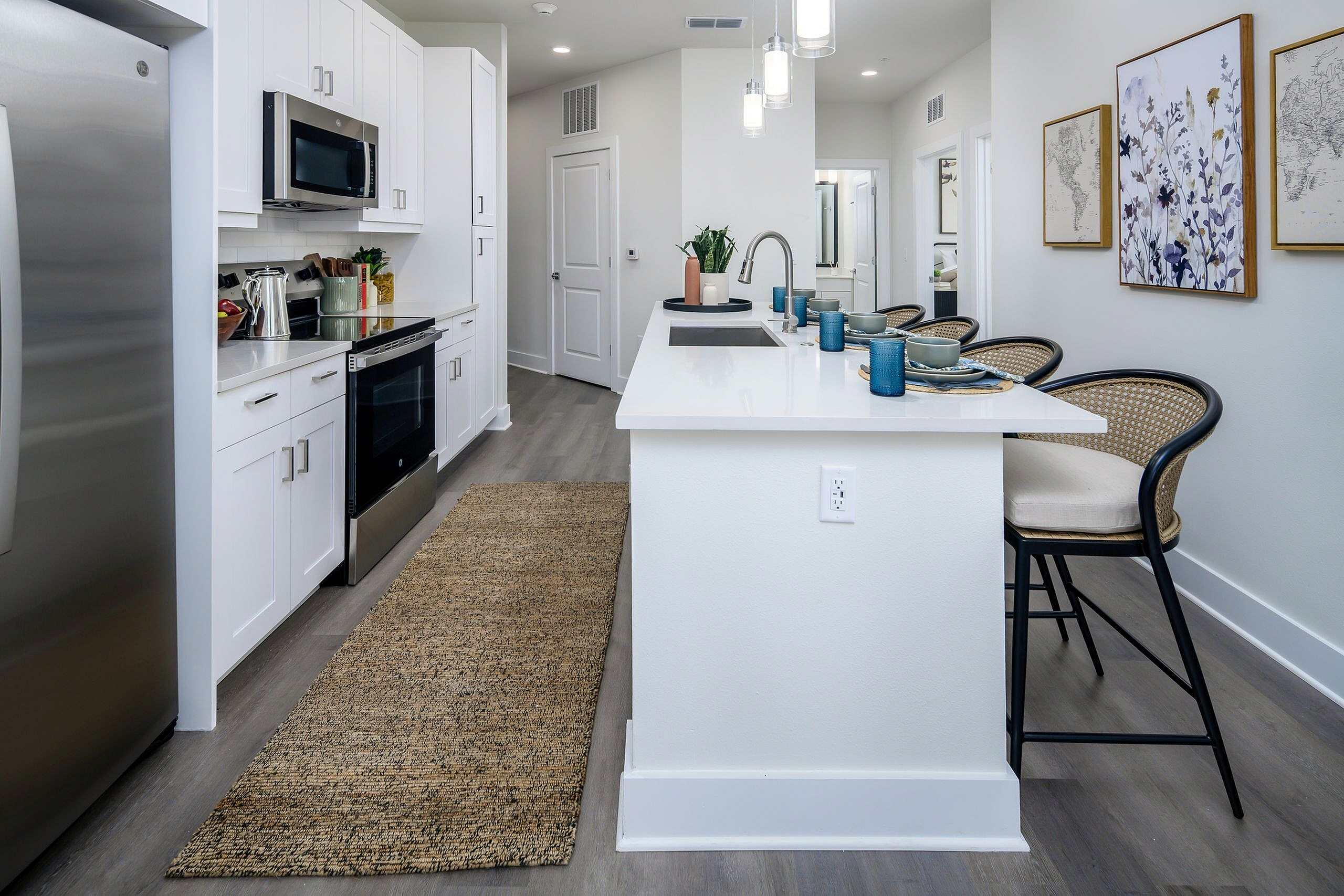 Modern kitchen with sleek white cabinets, stainless steel appliances, and an inviting breakfast bar with stylish seating.