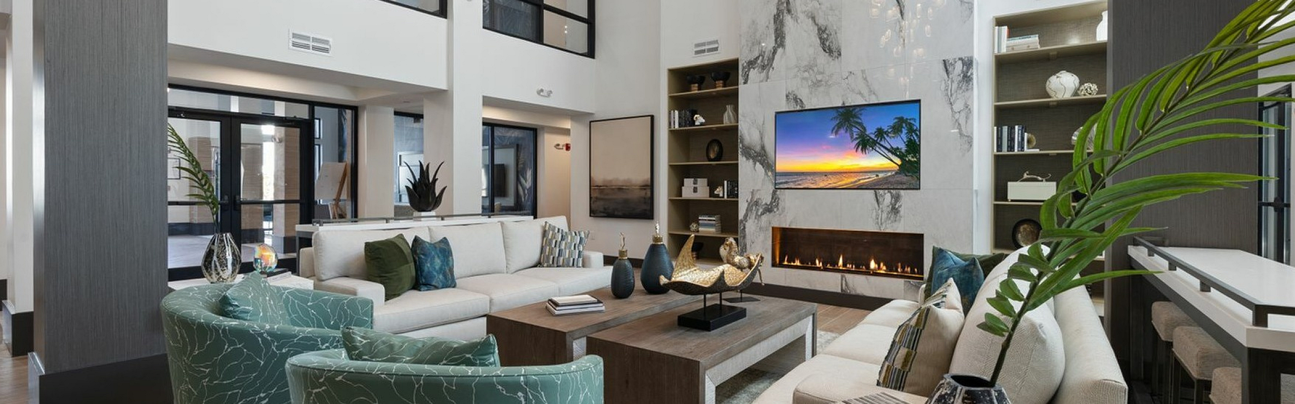 Luxurious modern living room with high ceilings, elegant marble fireplace, and chic teal round chairs, creating a sophisticated ambiance.