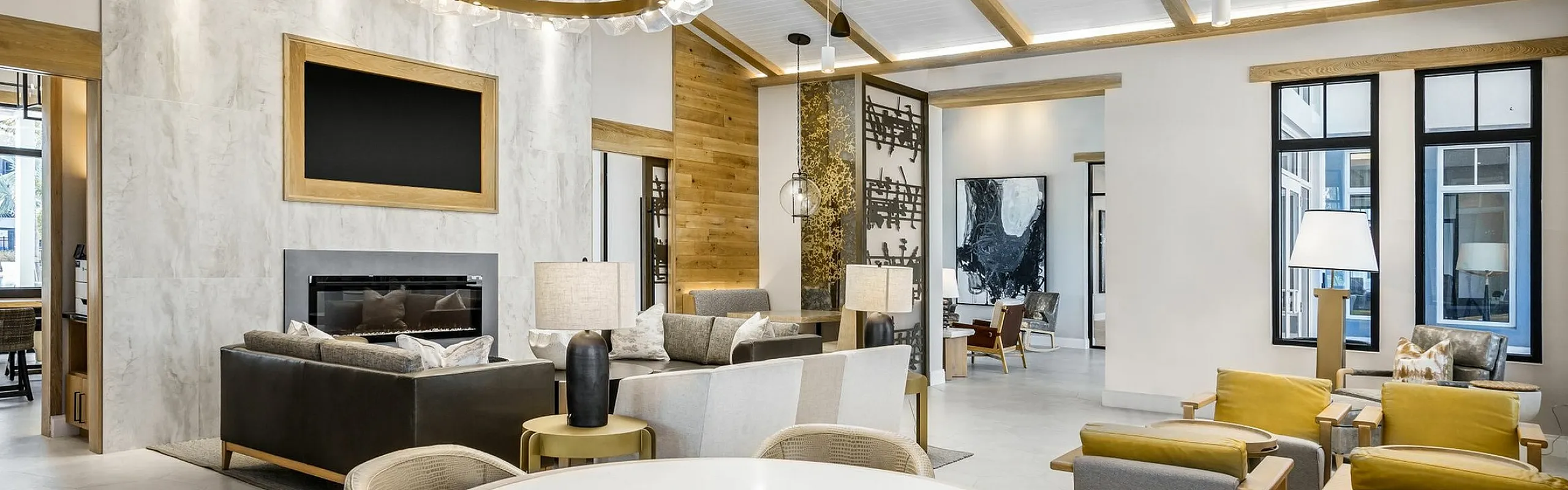 Elegant living space with vaulted ceiling, stylish seating area, and modern lighting, featuring a cozy fireplace and chic decor.