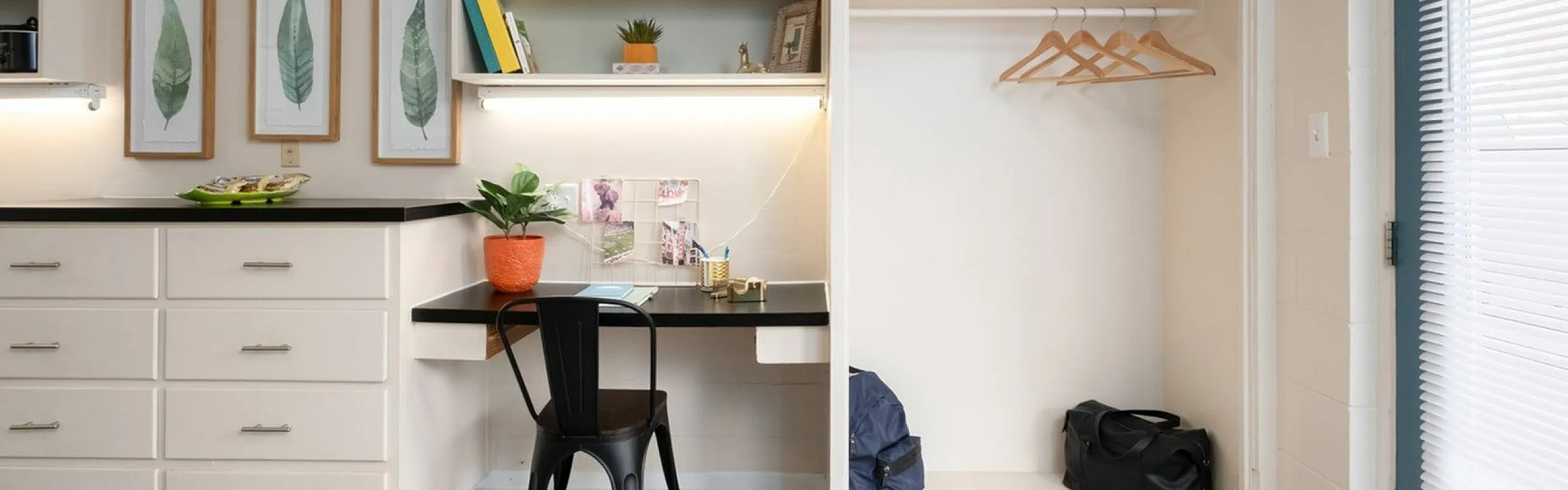 Contemporary study nook with built-in desk, shelving, and closet space, beautifully accented by leafy artwork and modern decor.
