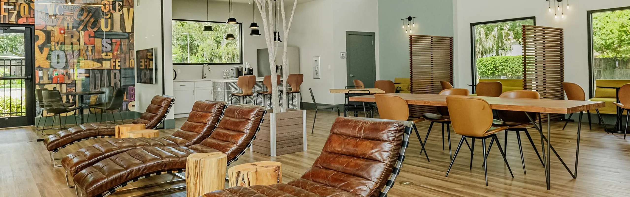 Sophisticated lounge area with modern design featuring leather chaise loungers, stylish pendant lighting, and a vibrant artistic mural.