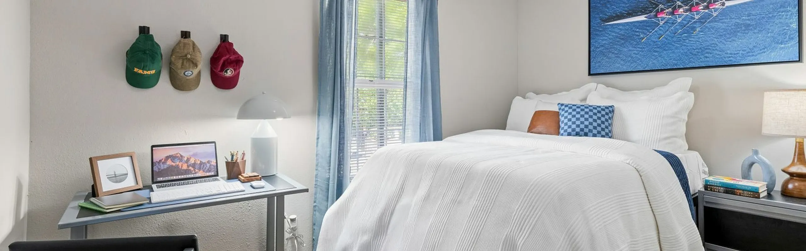 Cozy bedroom with a stylish desk setup, modern decor, and bright natural lighting creating a warm and inviting atmosphere.