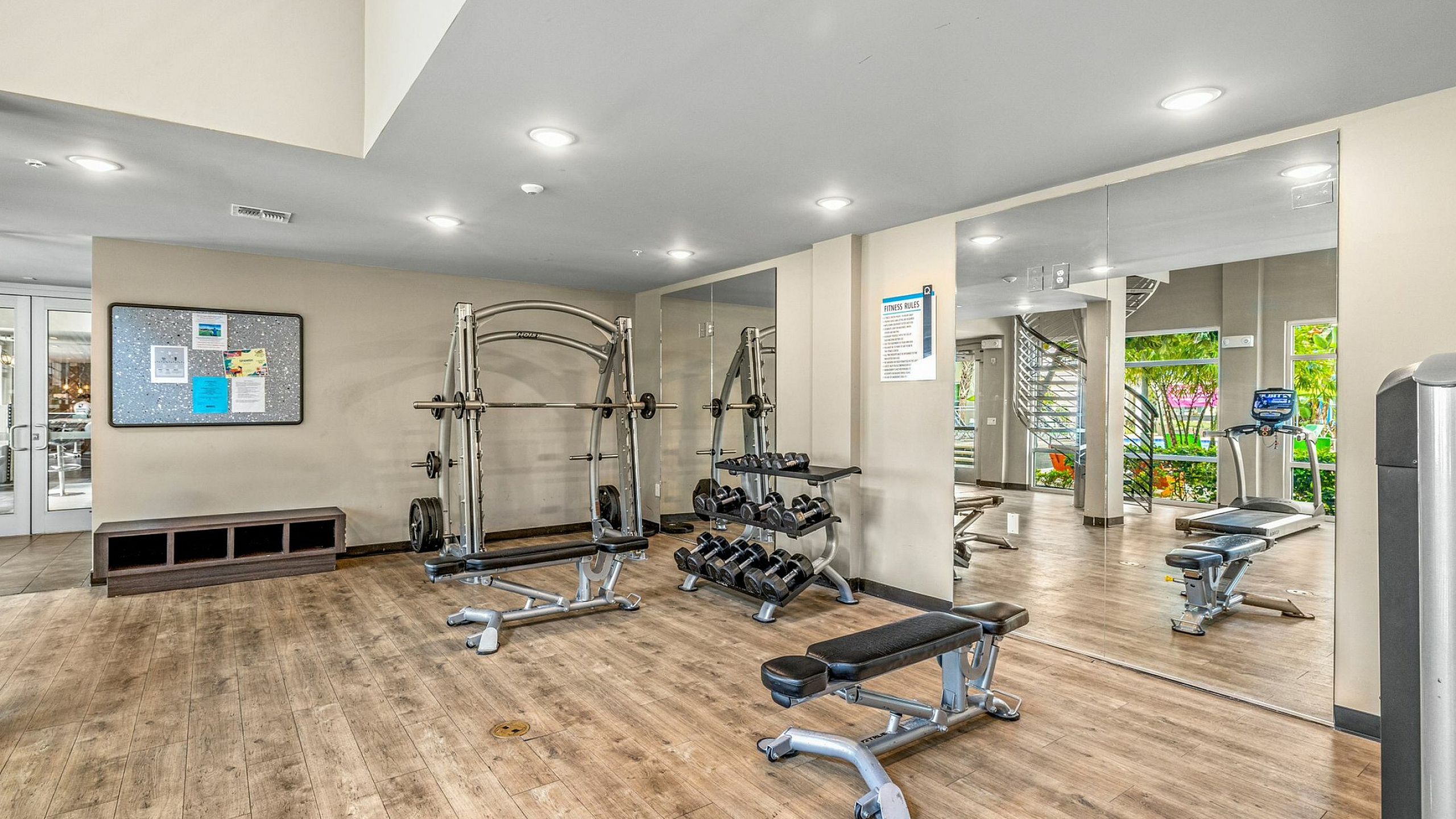 Modern fitness center with state-of-the-art gym equipment, mirrored walls, and natural lighting.
