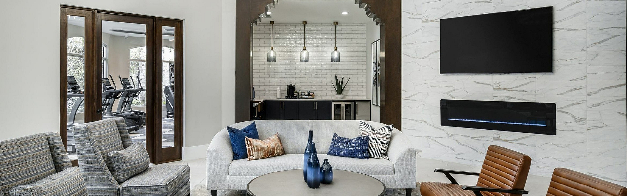 Elegant modern living room with stylish seating, chic decor, and a sleek wall-mounted TV, offering a luxurious and inviting ambiance.