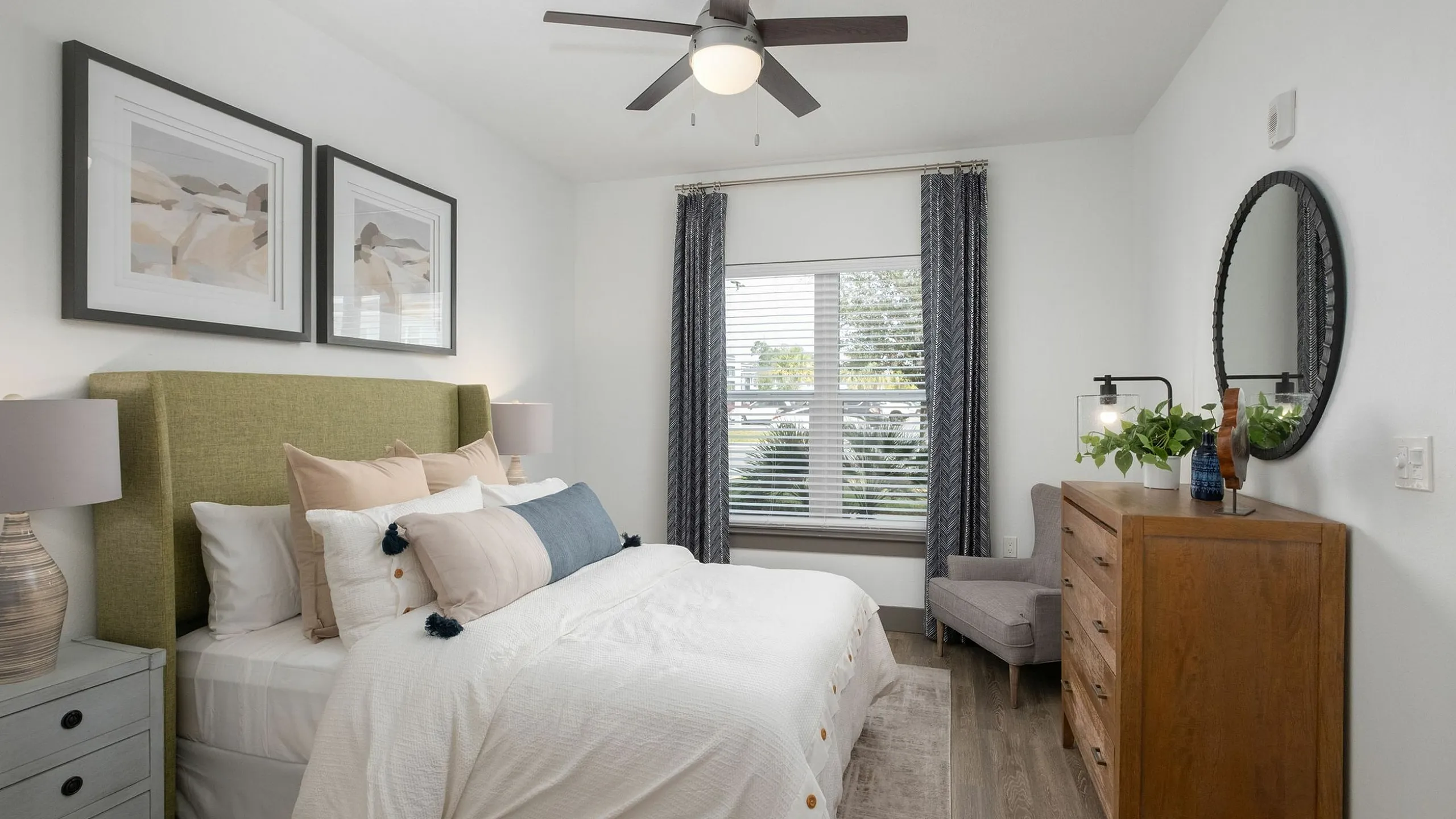 Bright and inviting bedroom with modern decor, featuring a plush bed, stylish artwork, and ample natural light through large windows.