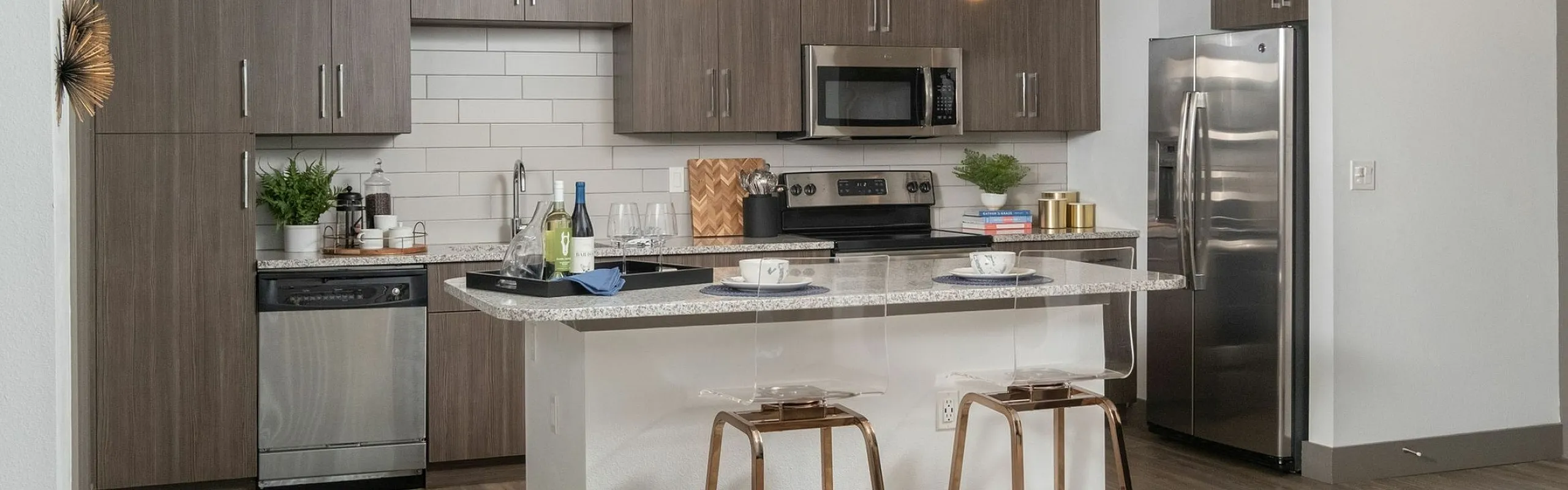 Modern kitchen with sleek cabinetry, stainless steel appliances, and a stylish breakfast bar illuminated by pendant lighting.