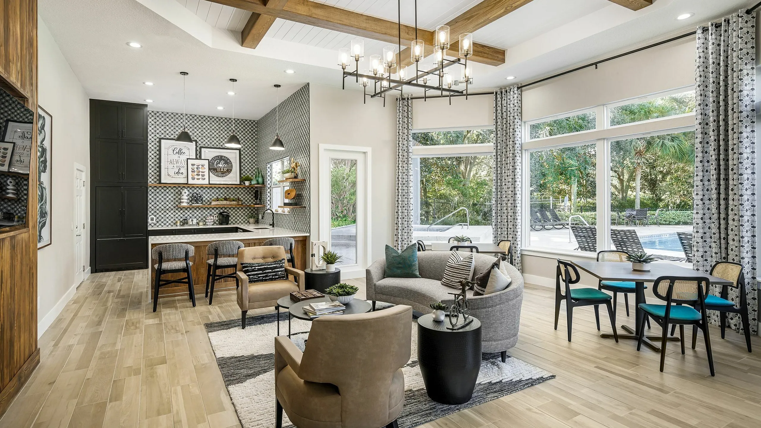 Chic open-concept living area with stylish furniture, wooden accents, and large windows overlooking a poolside view. Perfect blend of comfort and modern elegance.
