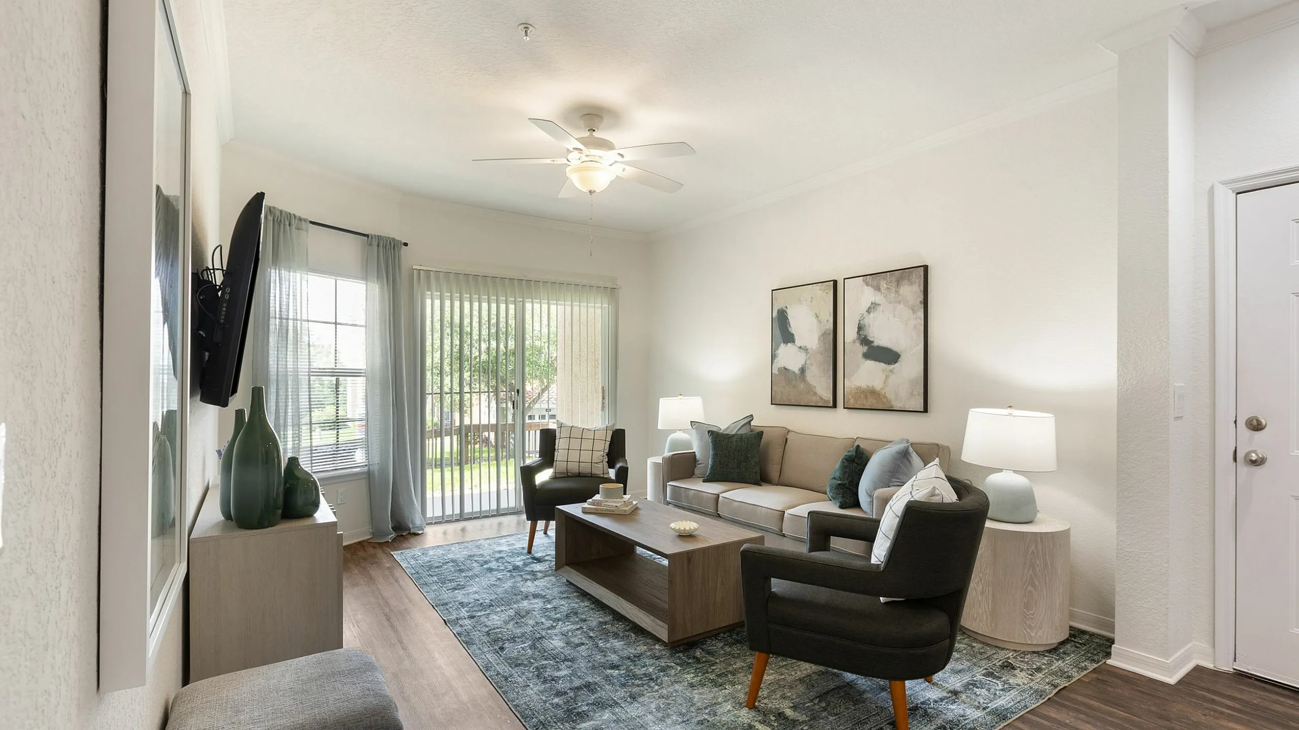 Inviting living room with modern decor, featuring large windows, comfortable seating, and stylish artwork creating a cozy ambiance.