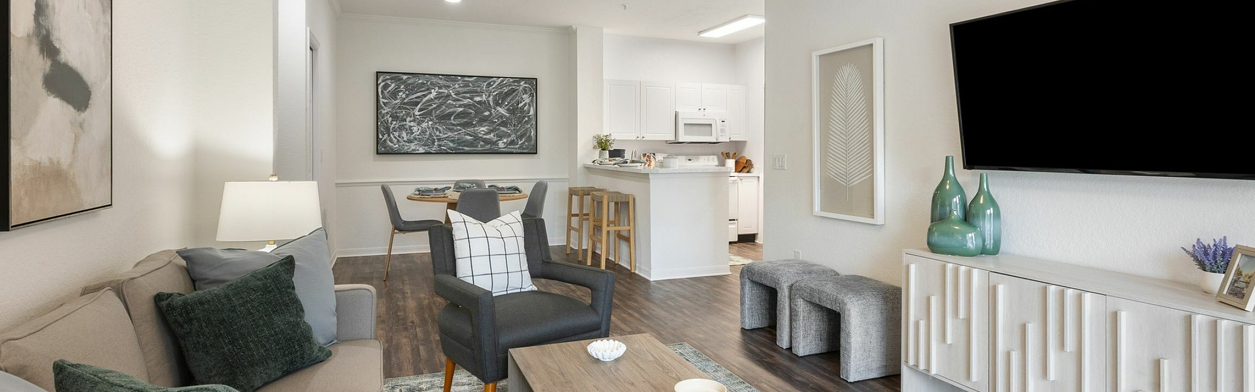 Elegant open-concept living room with modern decor, cozy seating, and a stylish dining area leading to a sleek kitchen.