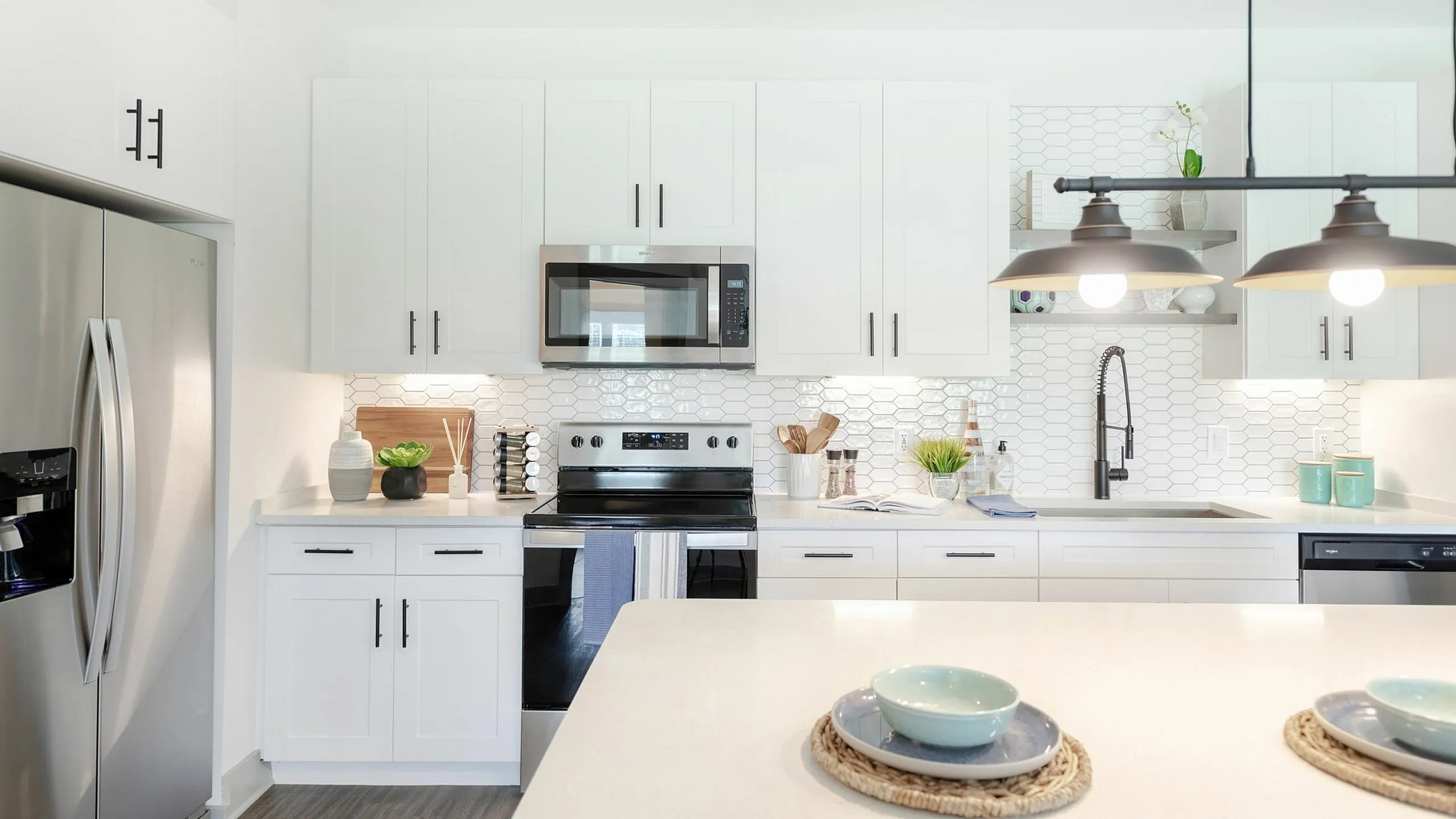 Bright modern kitchen with sleek white cabinetry, stainless steel appliances, and stylish hexagonal backsplash, perfect for culinary enthusiasts.