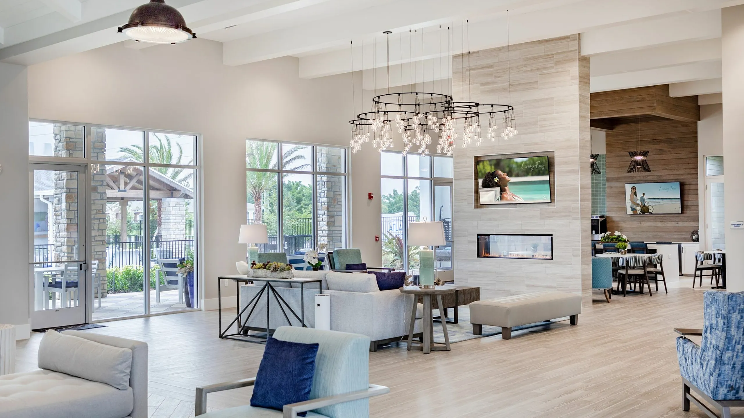 Bright and inviting lounge with modern furniture, large windows, and elegant lighting, offering a luxurious living experience.