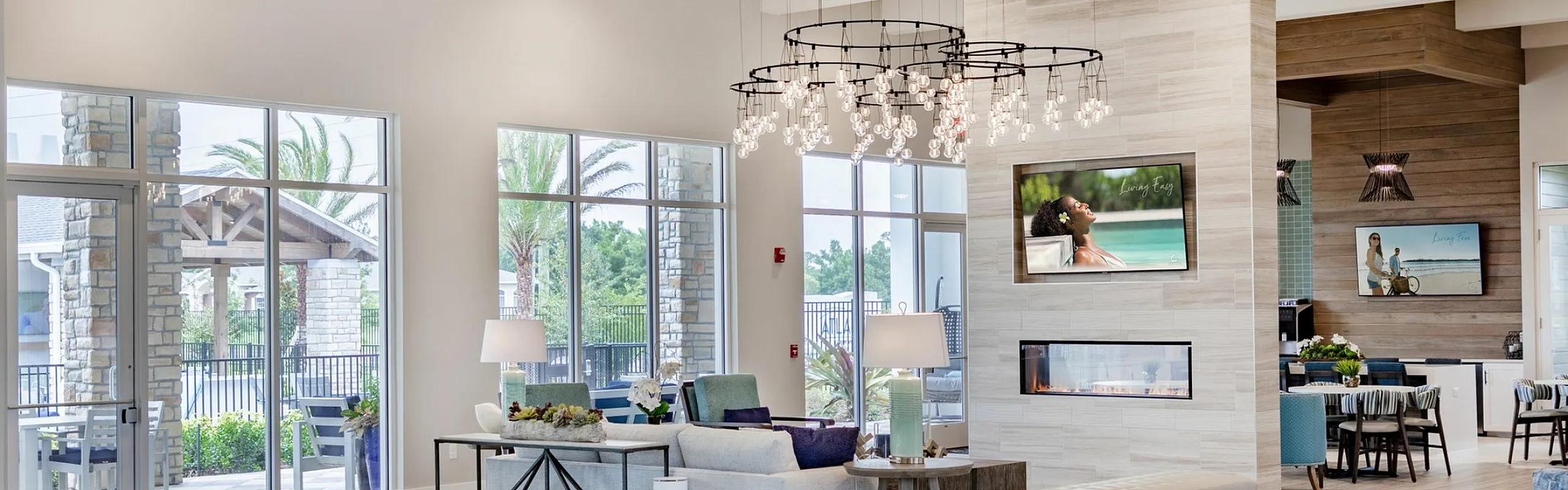Bright and modern apartment lounge featuring elegant decor, large windows with natural light, and a stylish open seating area.