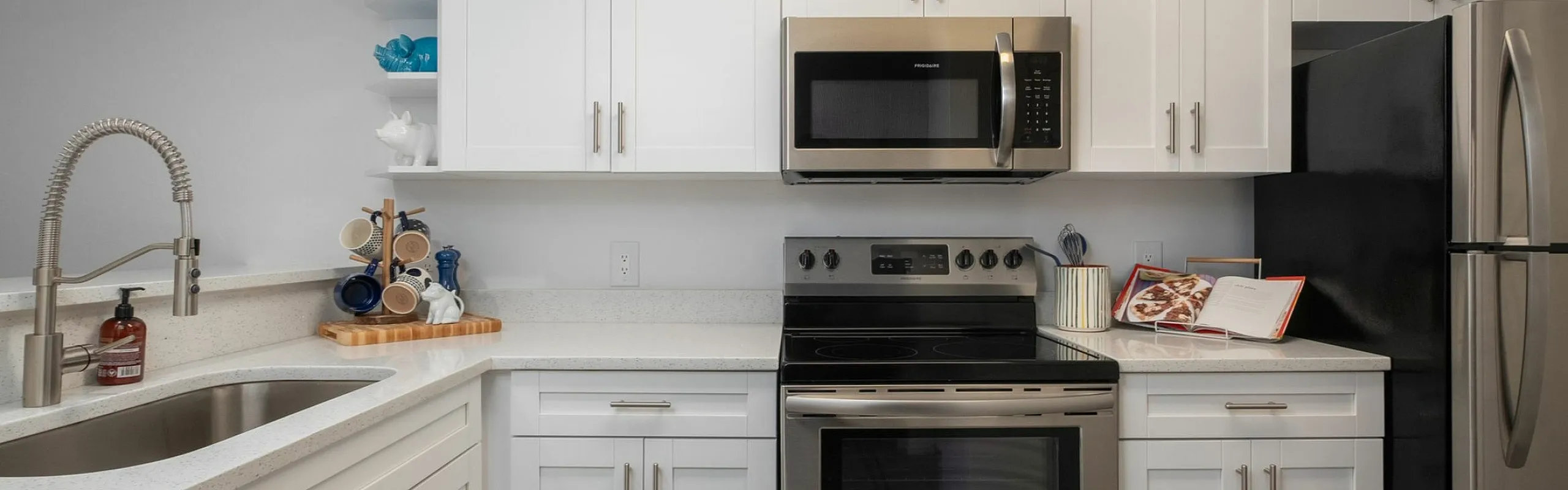 Modern kitchen with sleek stainless steel appliances, stylish white cabinetry, and elegant stone countertops.