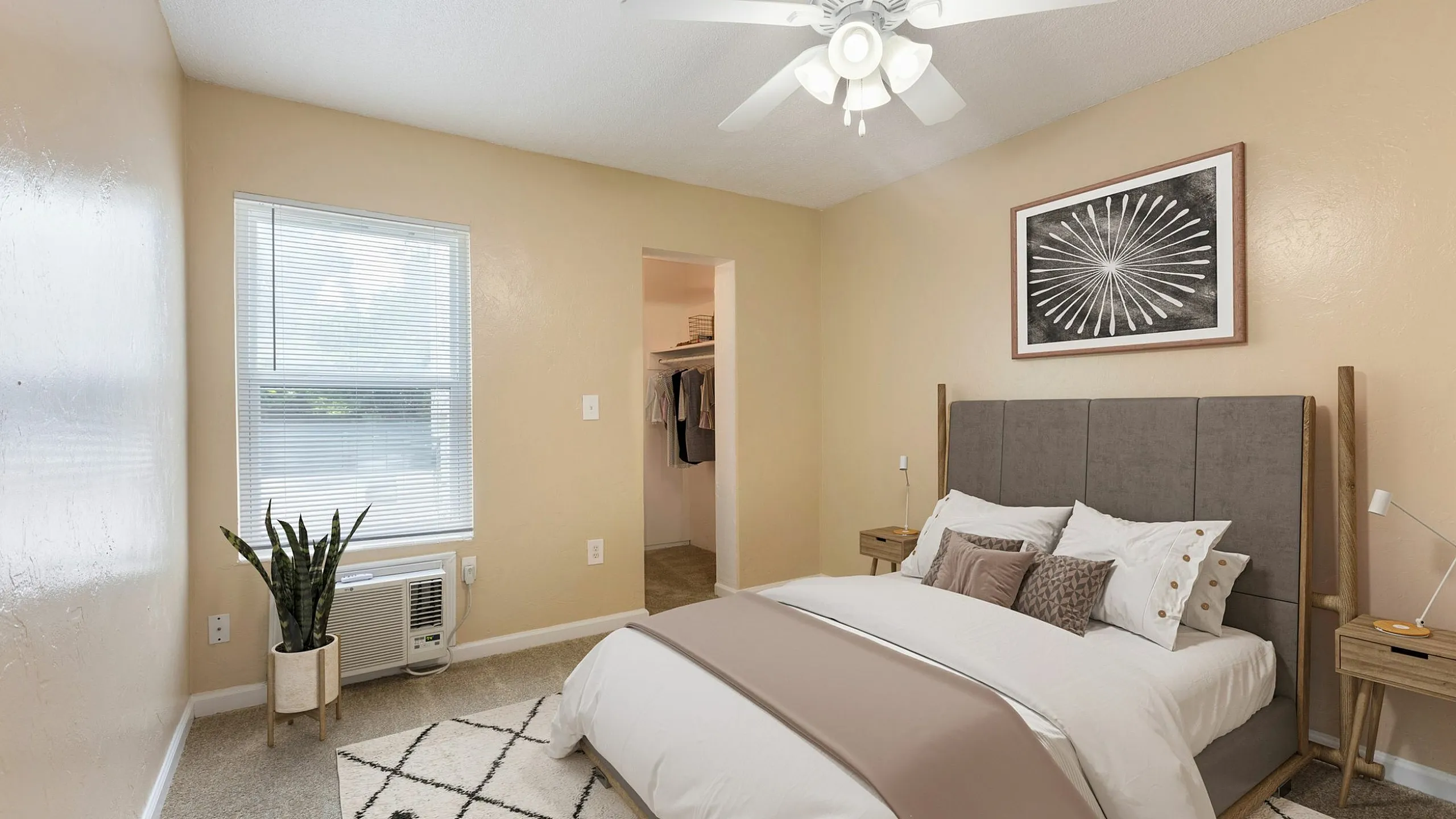 Inviting bedroom featuring a cozy bed with stylish pillows, elegant side tables, and a charming walk-in closet, illuminated by soft natural light and complemented by a decorative plant.